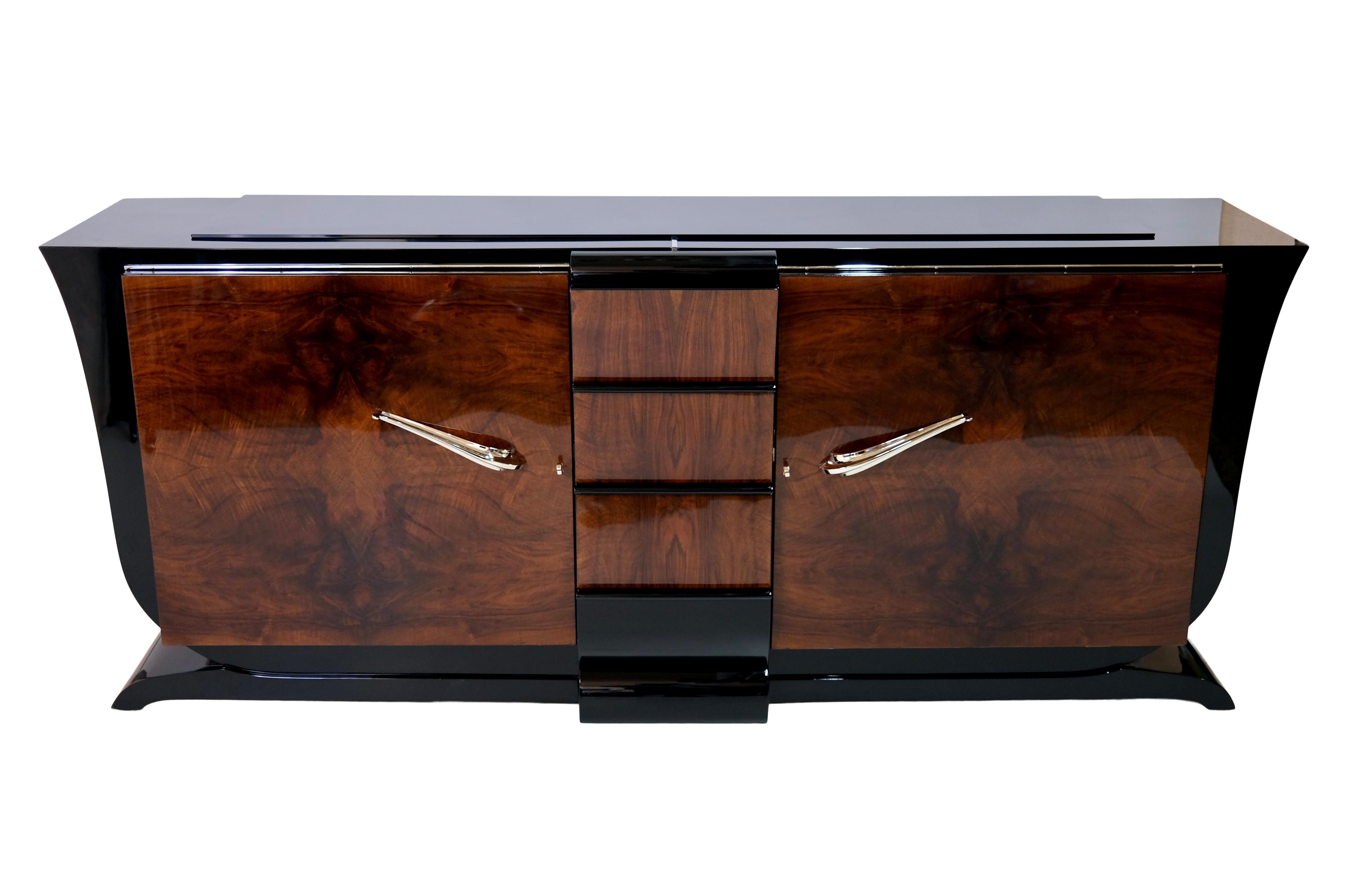 Sideboard with curved sides in typical shape  
Two hinged doors 
Drawers in the middle part 
Fronts in nut wood, high gloss lacquer 
Body in black piano lacquer, high gloss 
Original handles, freshly nickel plated 

Original Art Deco, France