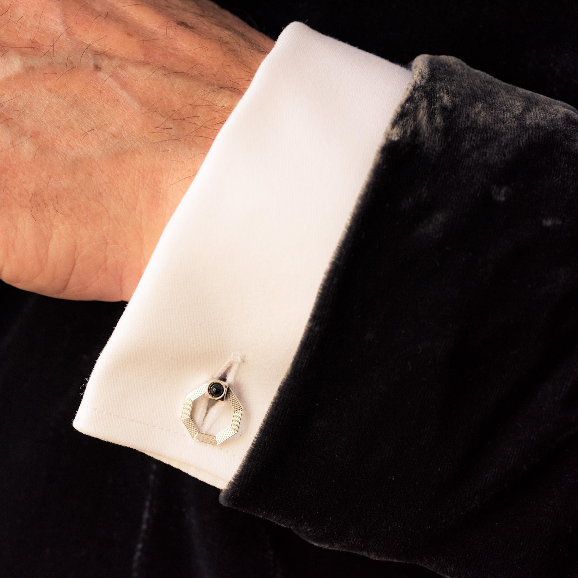 Pair of cufflinks in silver, weevil hallmark.
Each cufflink is formed by a cylinder, each end of which is adorned with a cube set with an black gem cabochon. Two octagons guilloched on one side, faceted on the other, fold to close the cuff.
Signed