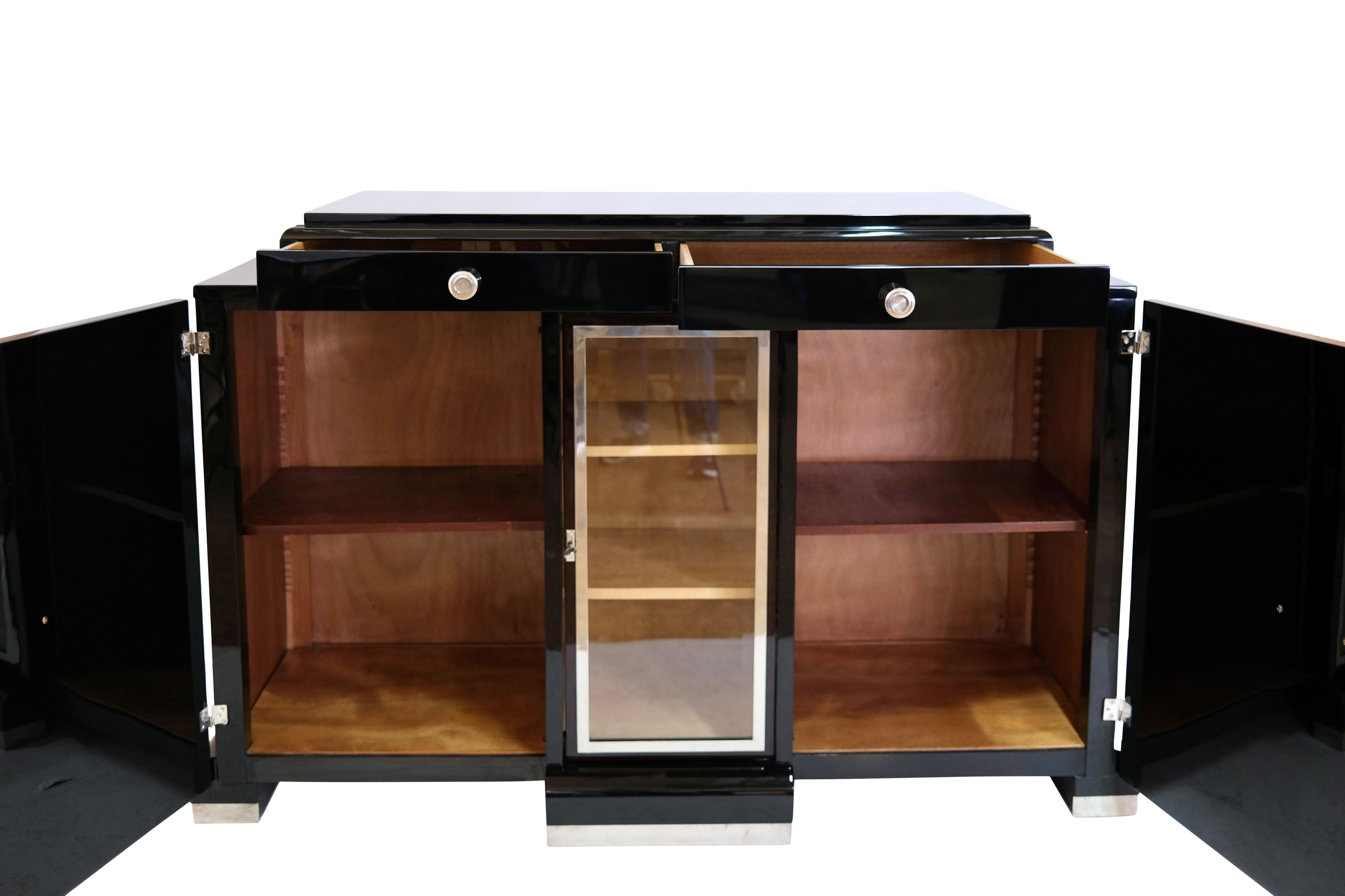 Two-door sideboard with small display cabinet and drawers
Fronts: probably ash stained, high gloss lacquered
Body: piano lacquer in black high gloss
Original fittings and metal applications

Cabinet compartment in maple (can be mirrored on