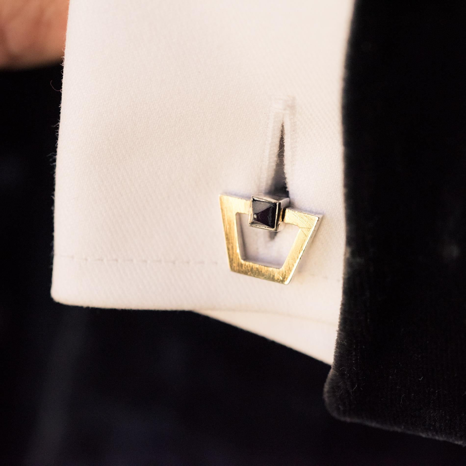 Pair of silver and vermeil cufflinks, mixed hallmark of eagle and boar's heads.
The central stem, of square section, is decorated with a black sugarloaf stone at each end on one of the cufflinks, and a blue stone for the other. The stones