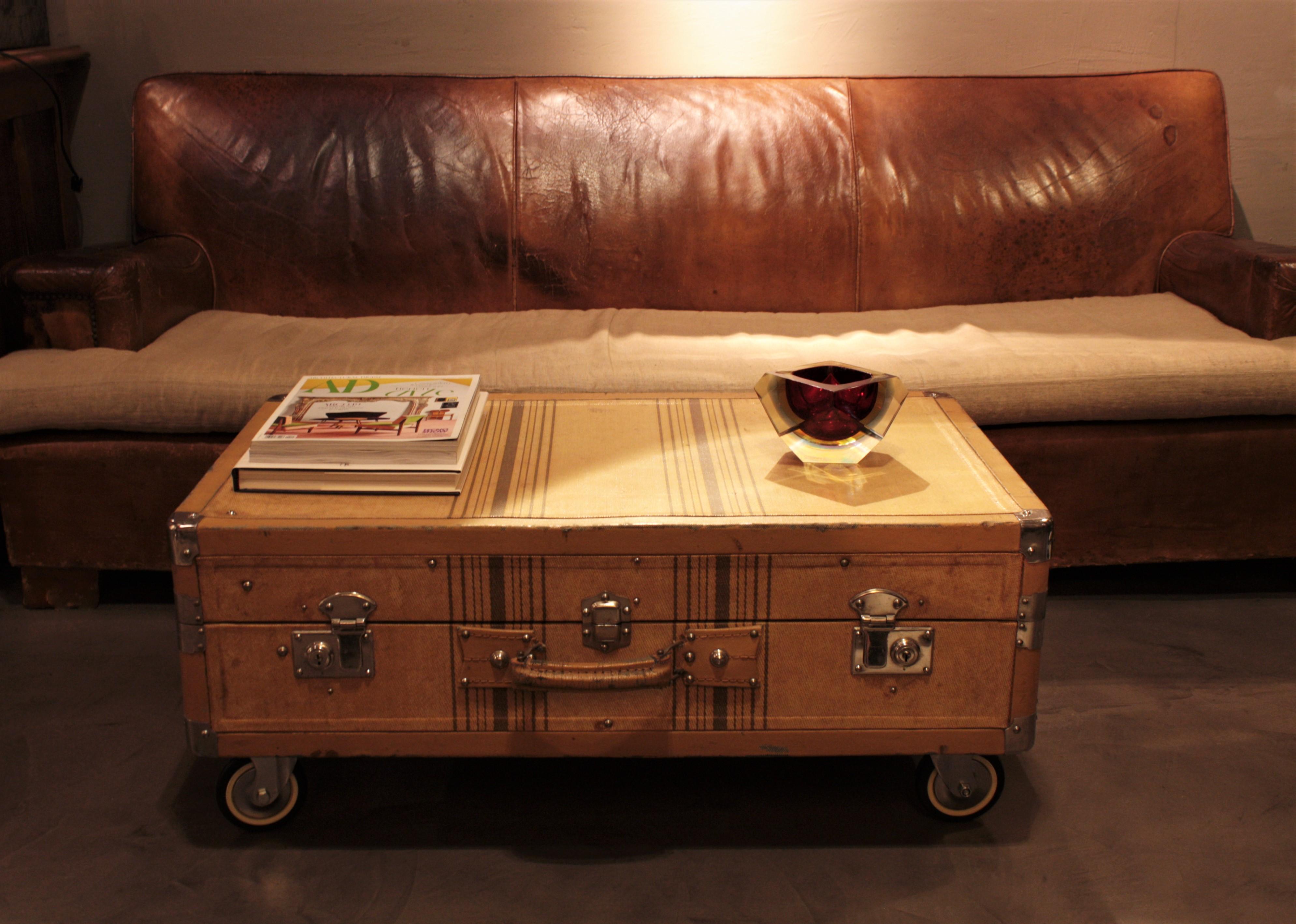 Belle valise / malle cabine en toile beige avec des rayures marron, serrures en métal et poignées en cuir, France, années 1930.
Serrures et goujons en acier chromé. Poignées en cuir sur le côté gauche et sur la partie avant. Il porte des étiquettes