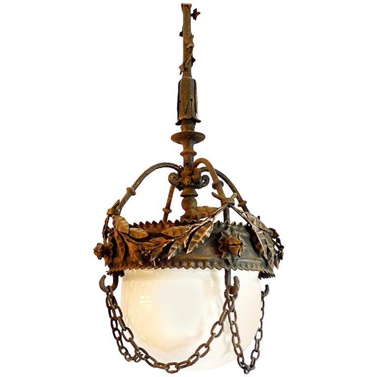 French 1930s mounted decorative cast iron pendant with milk glass globe and chain surround.