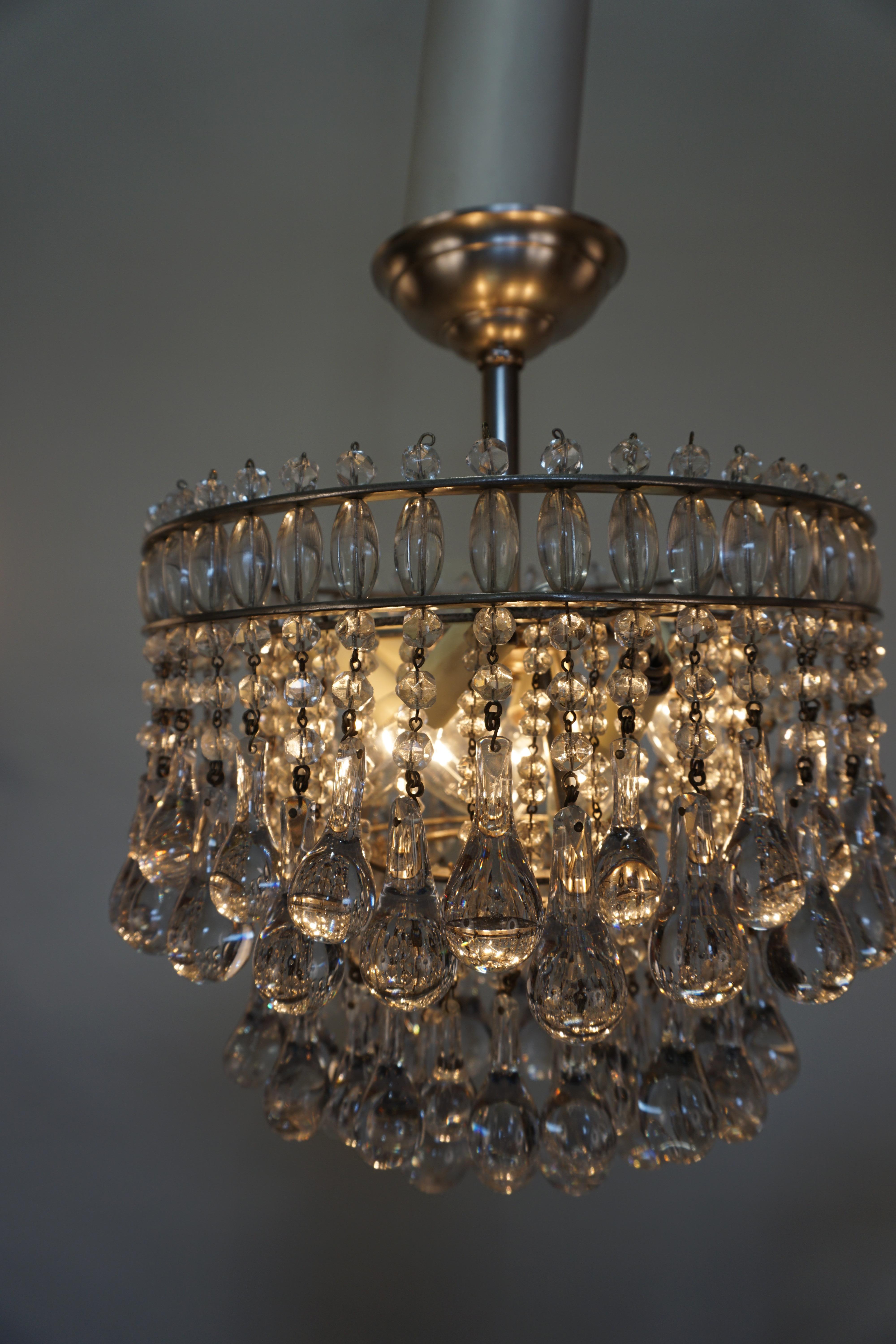 An exquisite six-light tear drop crystal and Classic style bronze frame chandelier.