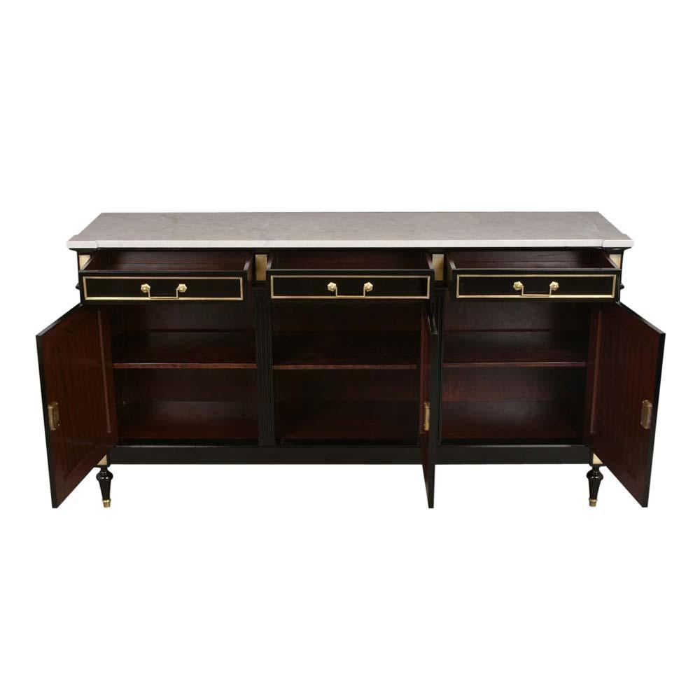 1930s Louis XVI style mahogany buffet with original Carrara marble-top, and elegant ebonized finish. The buffet has three drawers adorn with brass molding and handles, has plenty of storage space, with a adjustable wooden shelve. The bottom has 3