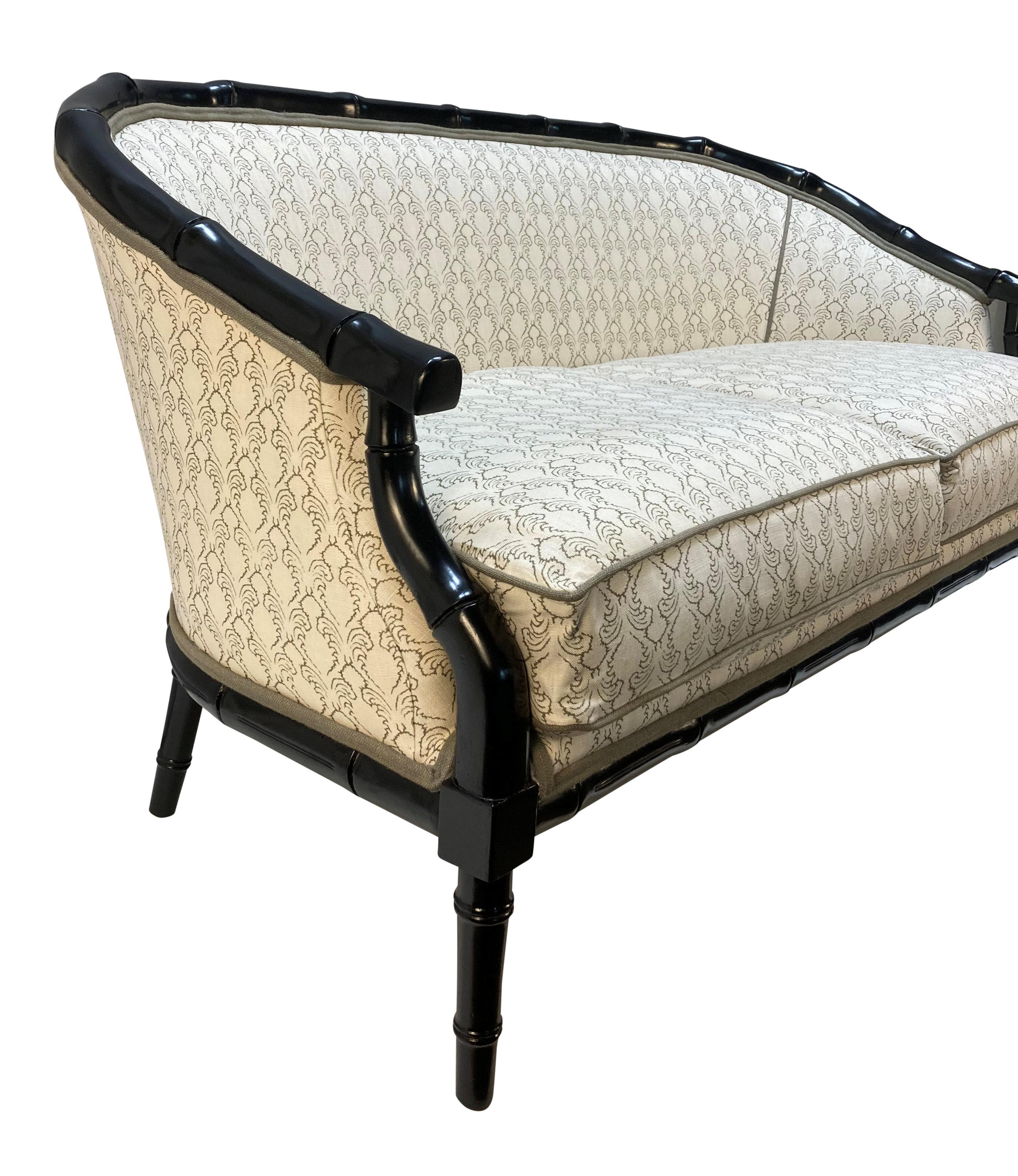 A French 1930s black lacquered faux bamboo sofa with two feather pads, upholstered in Soane fabric.