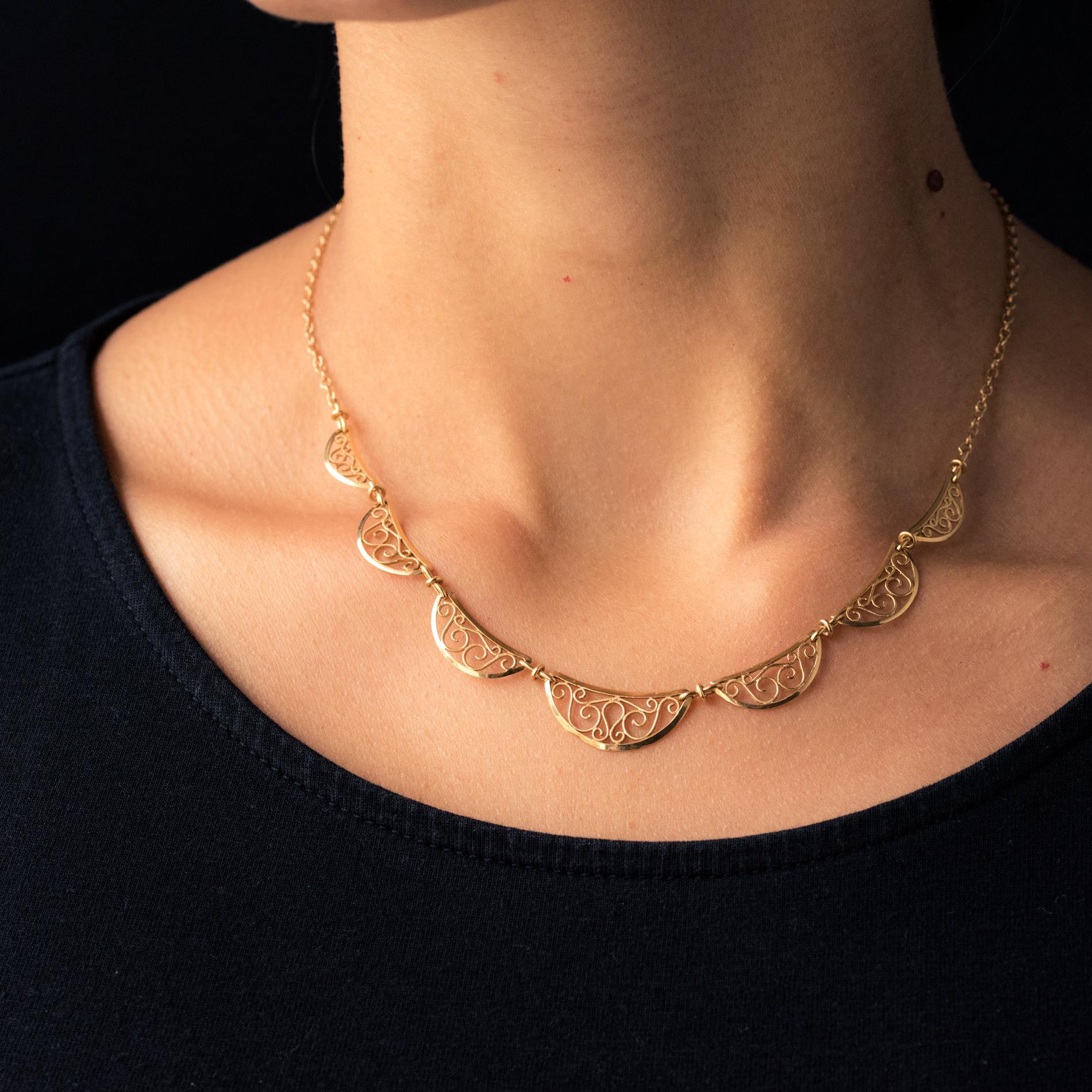 Necklace in 18 karat yellow gold, eagle's head hallmark.
The front of this drapery necklace is adorned with 7 half-moon drop patterns, openwork with filigree. The chain is a jaseron link.
Length : 40.7 cm, pattern height : 7.3 mm, pattern width :