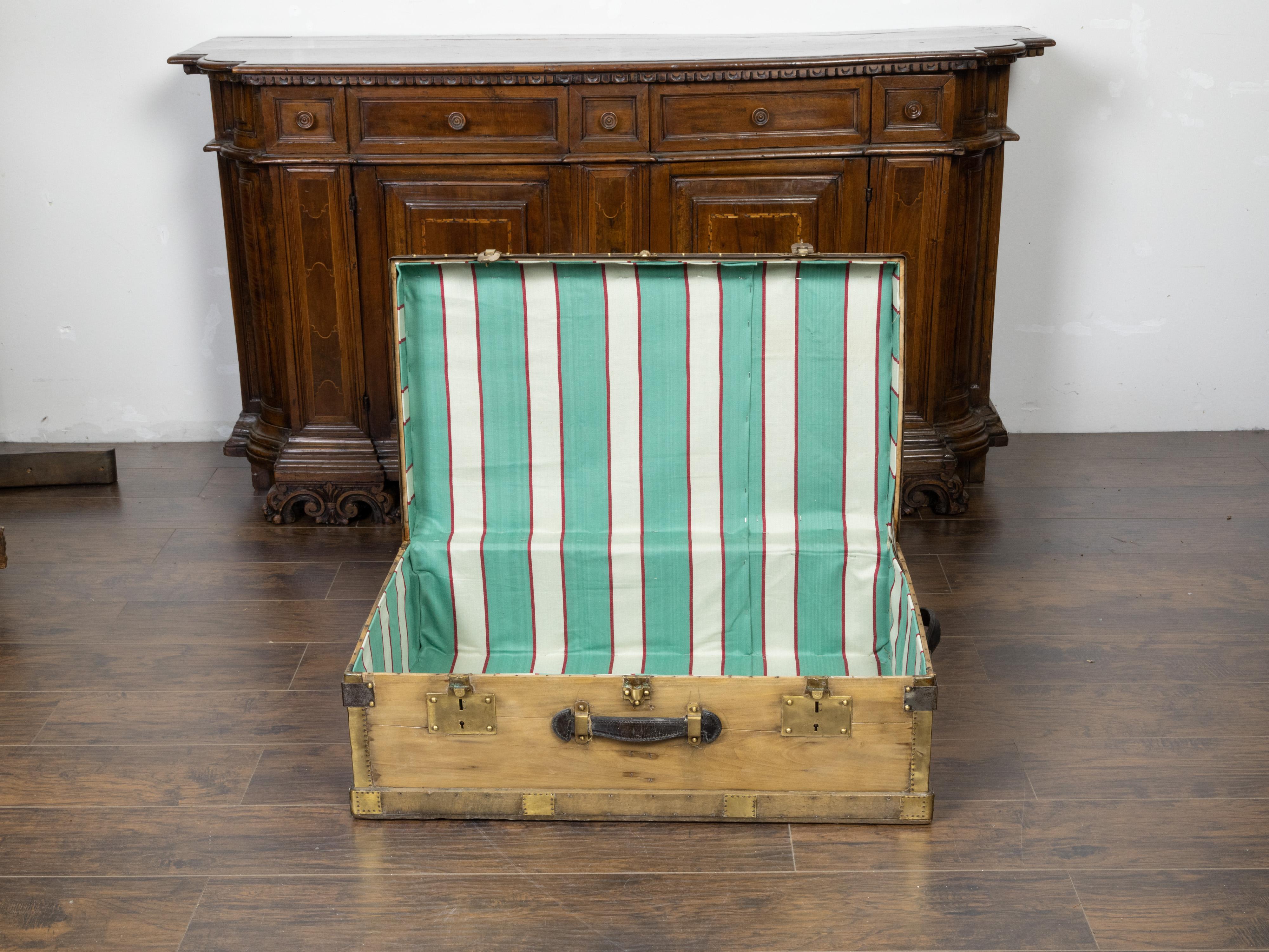 A French Lavolaille pine trunk from the early 20th century, with brass accents and monogram. Created in France during the second quarter of the 20th century, this pine trunk features a rectangular lid opening to reveal a fabric lined interior.