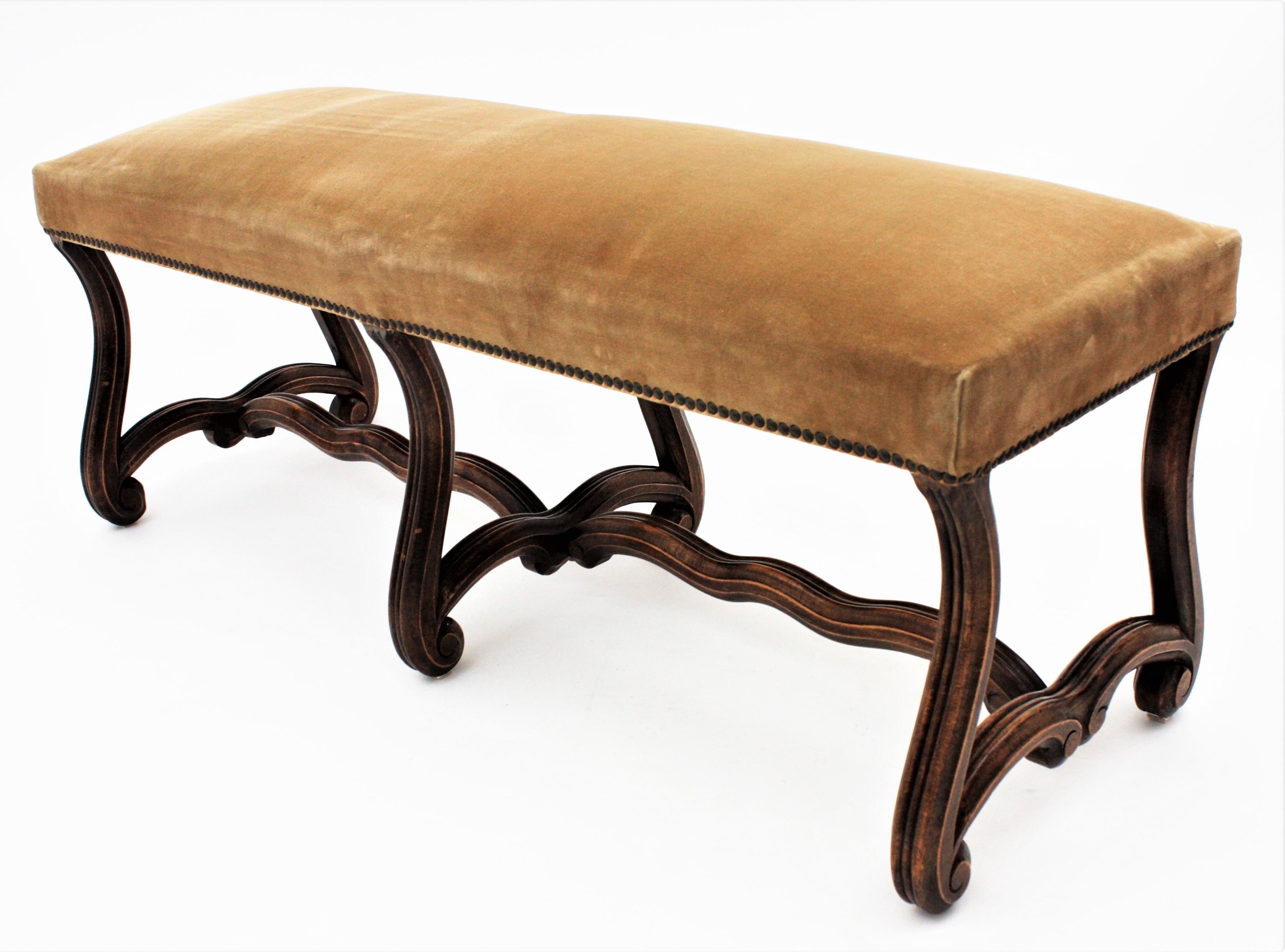 A large 19th century backless Louis XIV style bench or stool raised on six Os de Mouton hand carved walnut wood legs with stretcher, France, circa 1930.
This stylish banquette has scrolled accents on the legs.
This bench is in exquisite fully