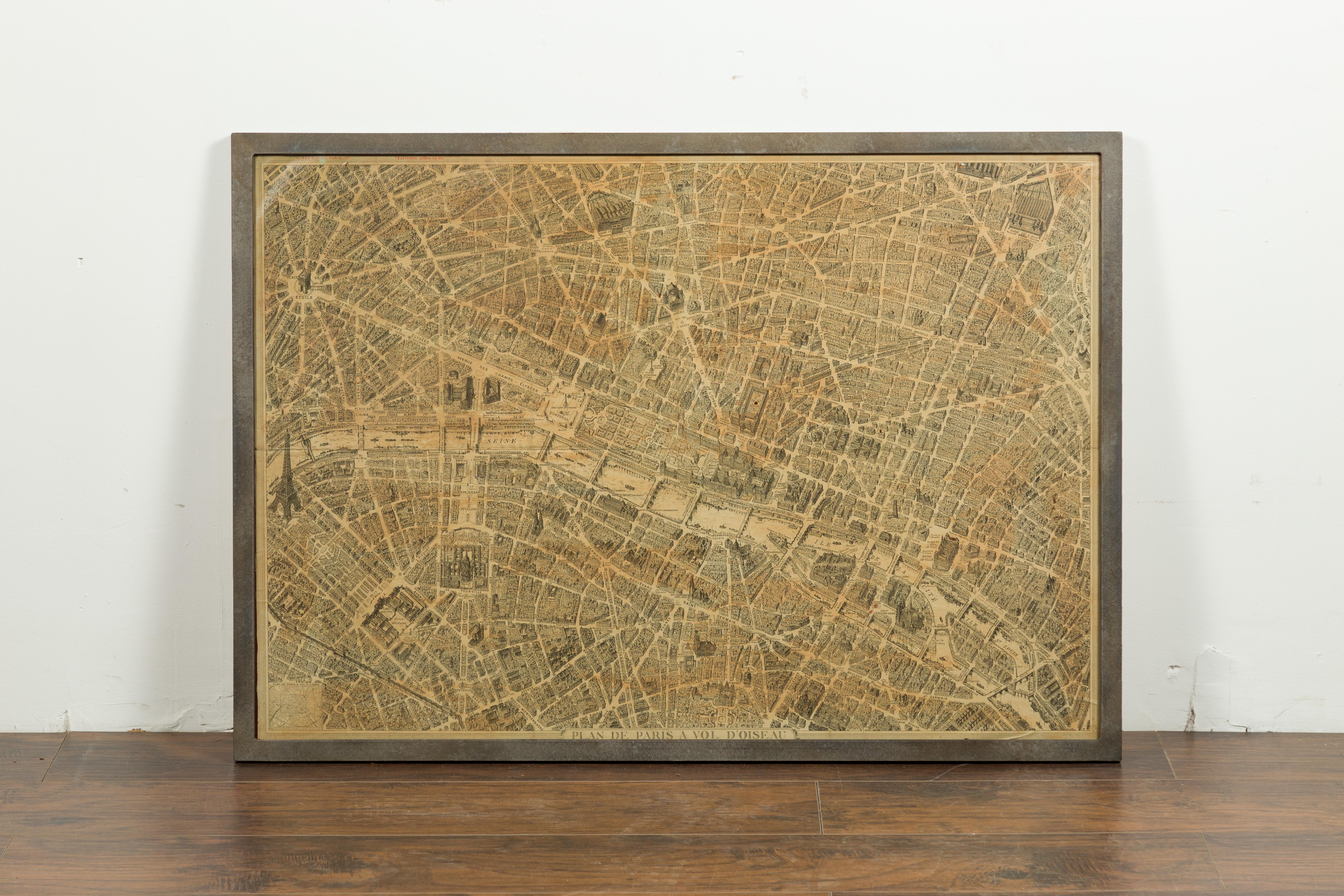 Un plan de Paris datant du début du 20e siècle, avec un cadre en fer personnalisé. Créée à Paris dans le deuxième quart du 20e siècle, cette carte de Paris à vol d'oiseau présente la ville lumière telle qu'elle était avant les années 1950. Le