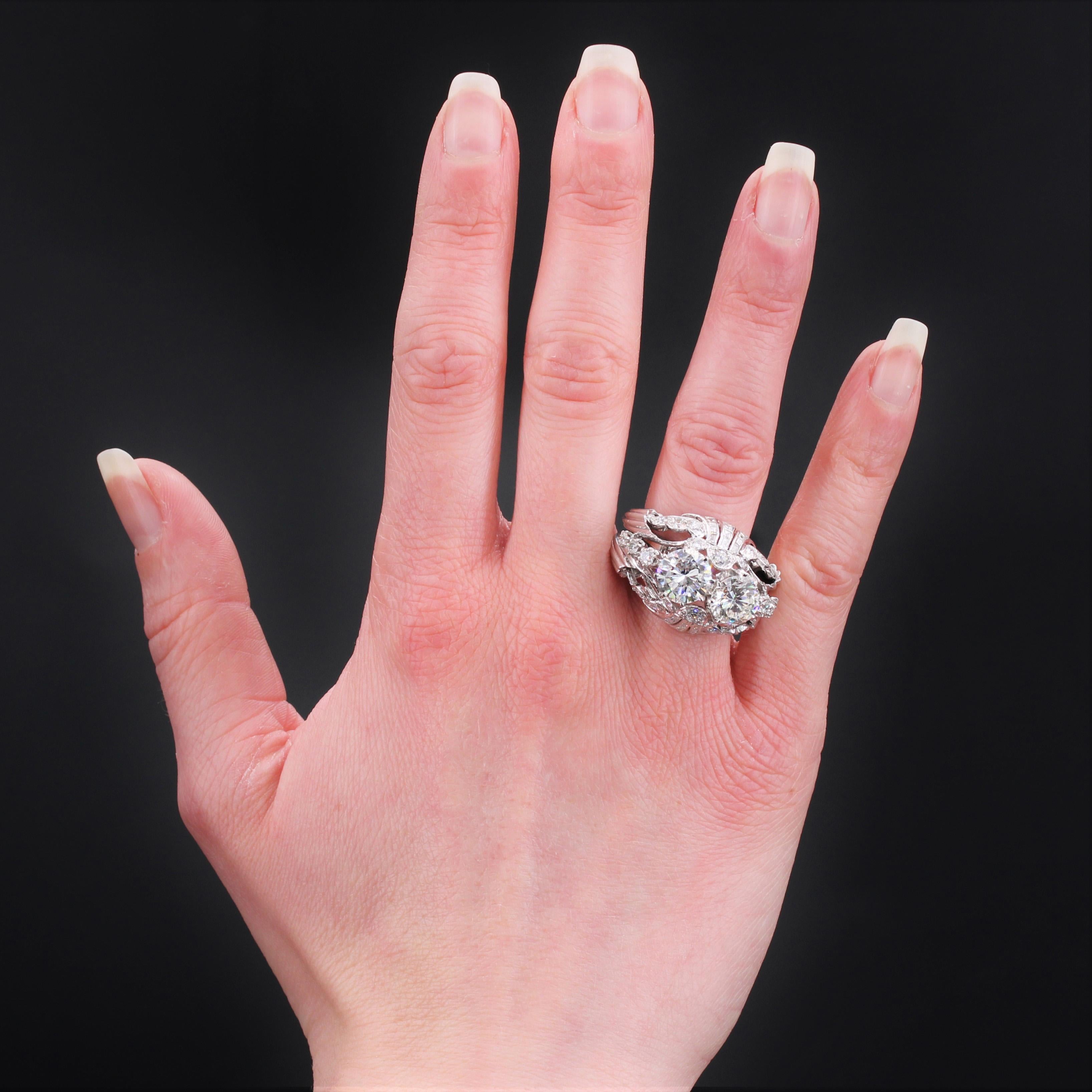 Ring in platinum, dog head hallmark.
Important openwork dome ring, it is set with claws on its top with 2 modern brilliant- cut diamonds. The top of the dome of the setting is openworked and adorned with modern brilliant- cut diamonds, baguette and