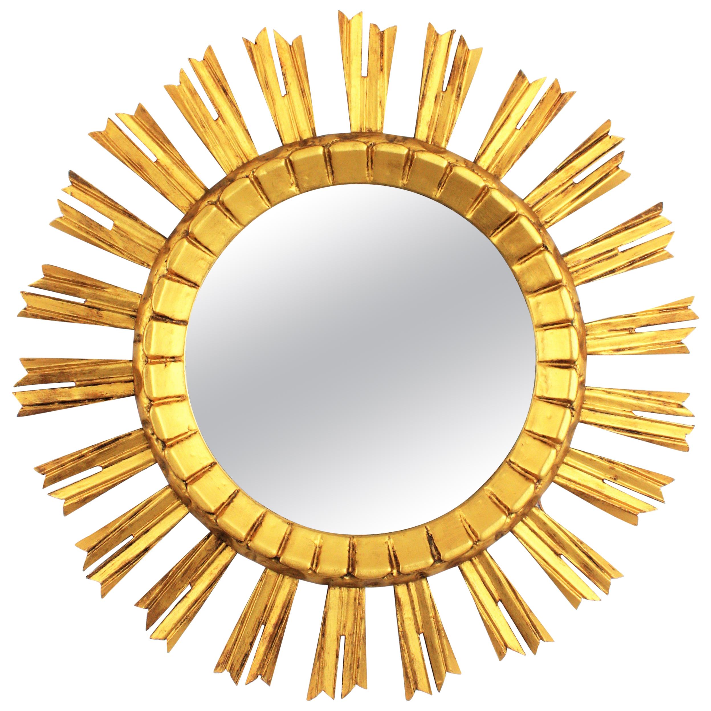 Eye-catching Baroque style sunburst / starburst wall mirror. France, 1930s. 
The mirror is made in carved wood, covered with gesso and has gilt finish.
Lovely to be placed alone or creating a wall composition with other sunburst mirrors.
Overall