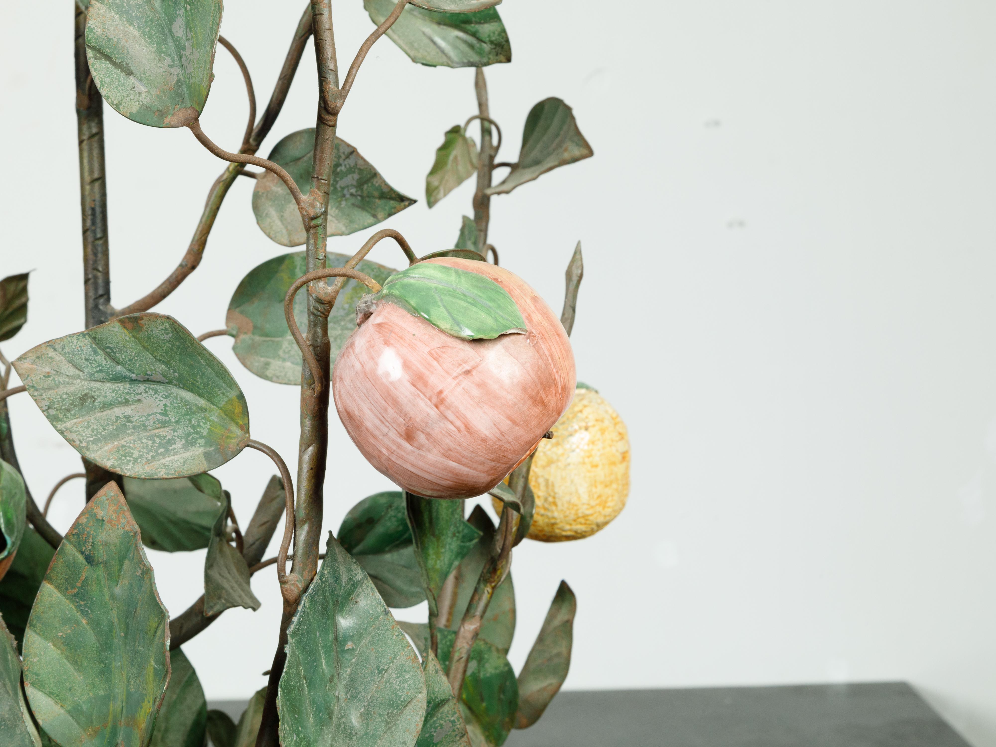 A French tôle and glass tree in pot from the mid 20th century, with orange and yellow fruits. Created in France during the second quarter of the 20th century, this botanical sculpture depicts a fruit tree bearing soft orange and yellow fruits.