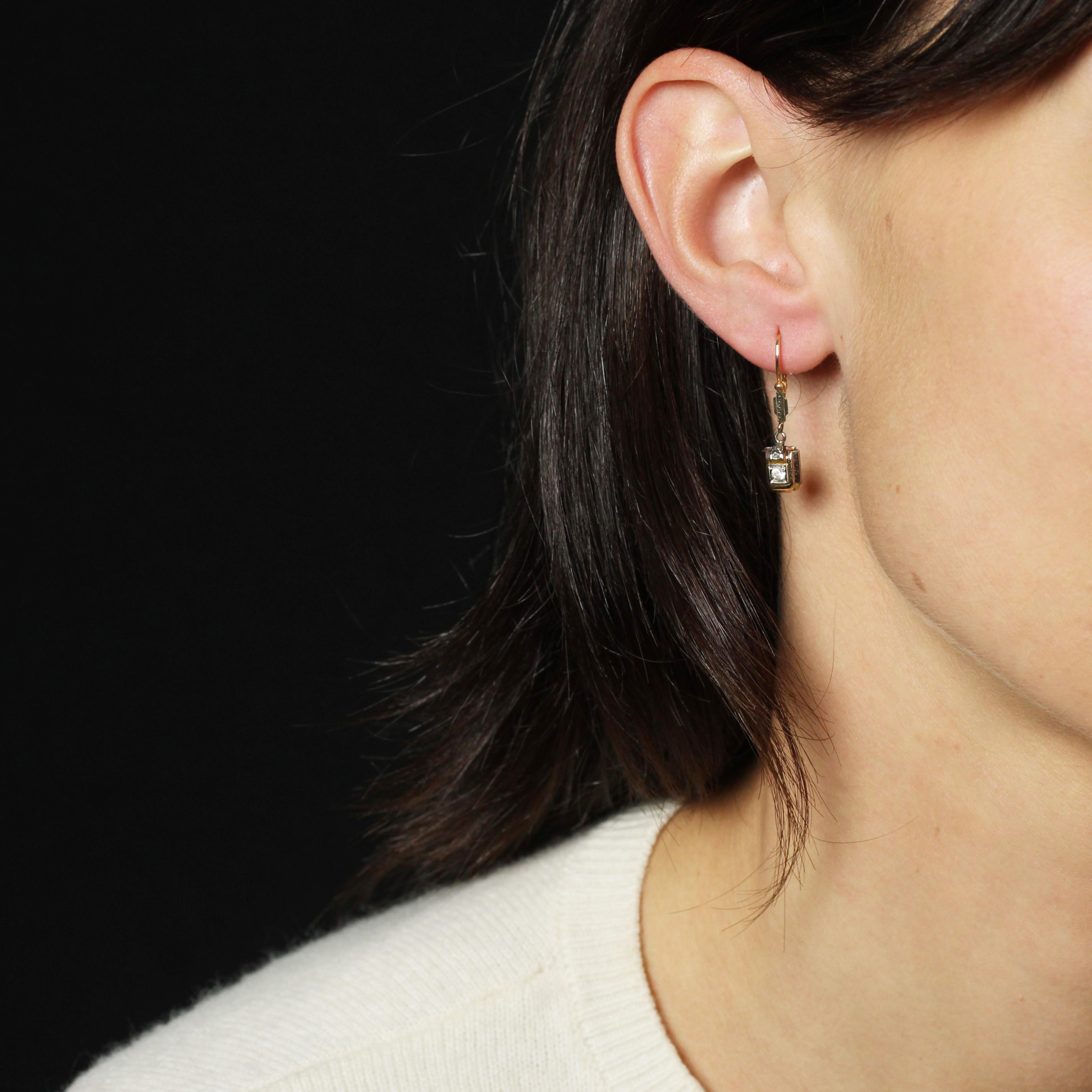 For pierced ears.
Earrings in 18 karat rose and white gold, eagle head hallmark.
A small pair of antique earrings, held in place by a drop clasp that threads through the back and is adorned with a geometric design in white gold decorated with