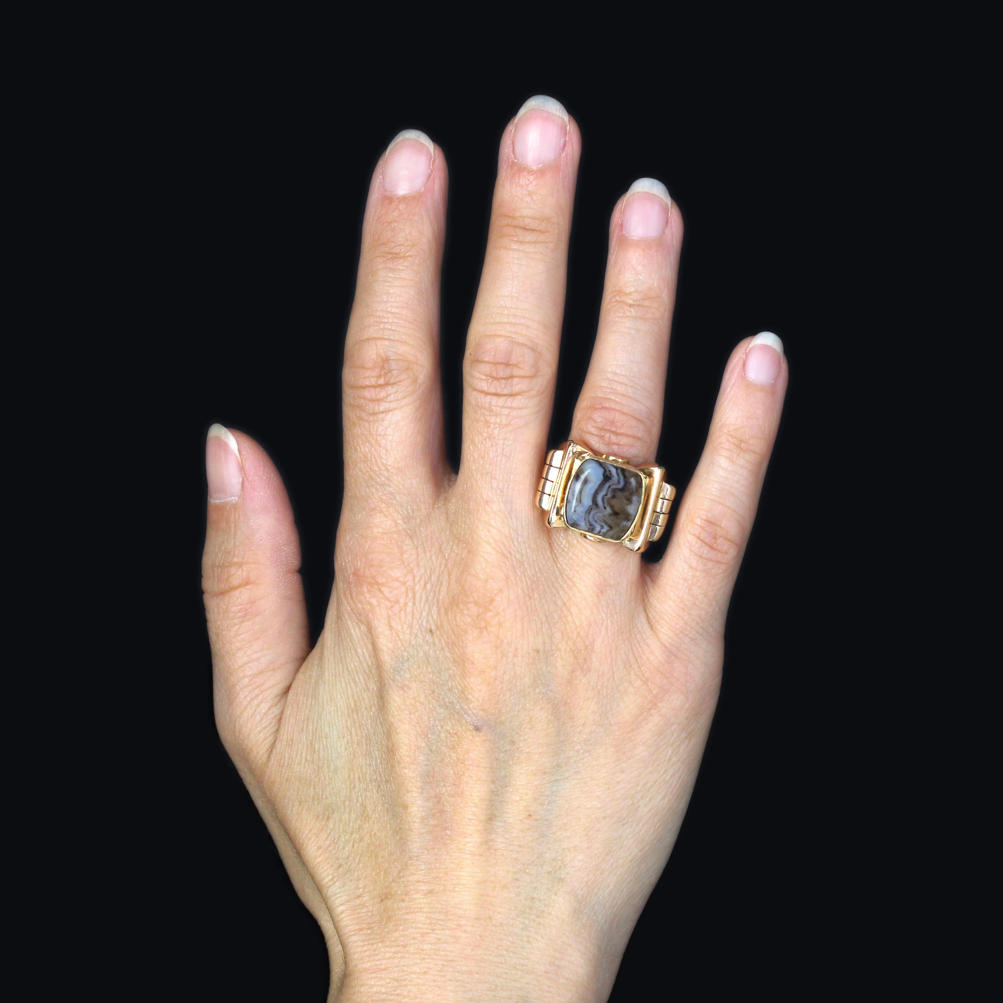 Anillo de oro amarillo de 18 quilates, sello de cabeza de águila.
Importante y macizo anillo de sello antiguo, su montura forma un nodo cuyo centro está decorado con un cabujón  de ágata zonificada. La salida del anillo está decorada por ambos