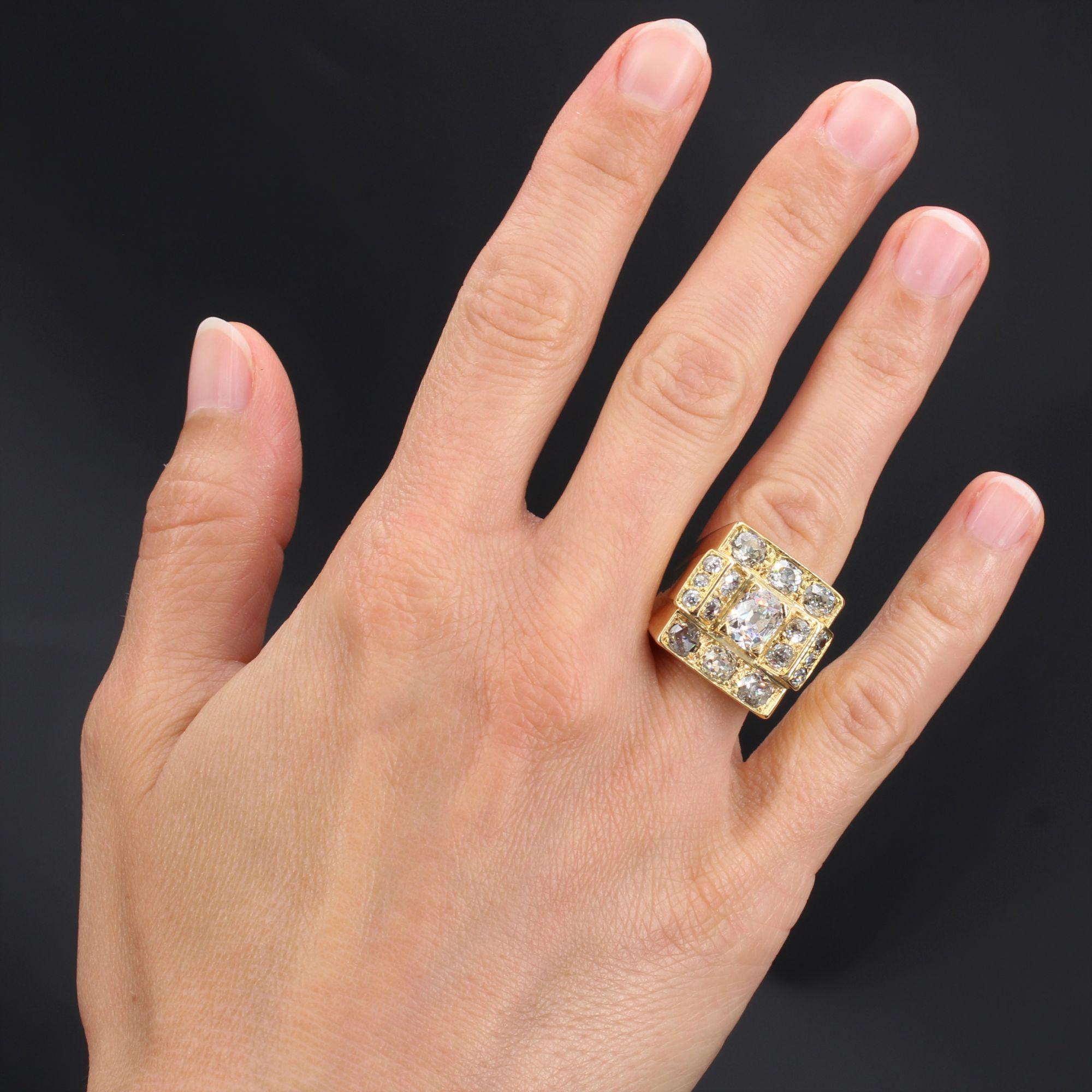Ring in 18 karat yellow gold, eagle head hallmark.
Geometrically shaped, this imposing tank ring is set with an antique step-cut diamond, supported by two triangle-shaped motifs set with antique brilliant-cut diamonds. On both sides, the edges are