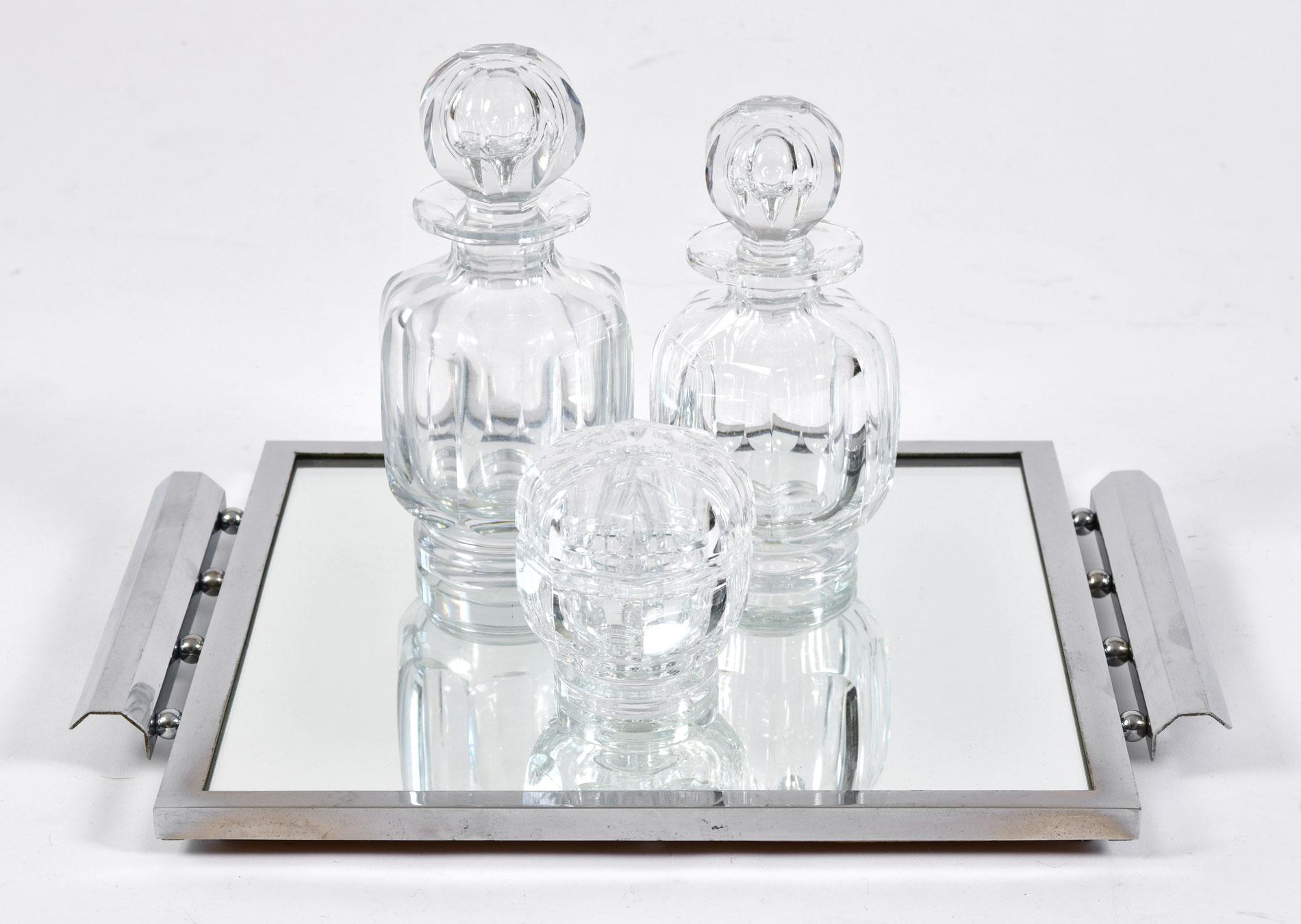 Beautifully shaped Baccarat crystal dressing-table set of three pieces. The faceted crystal bottles with multi-faceted octagonal stoppers are perfect for holding large amounts of perfume. The octagonal crystal lidded pot is perfect for small item