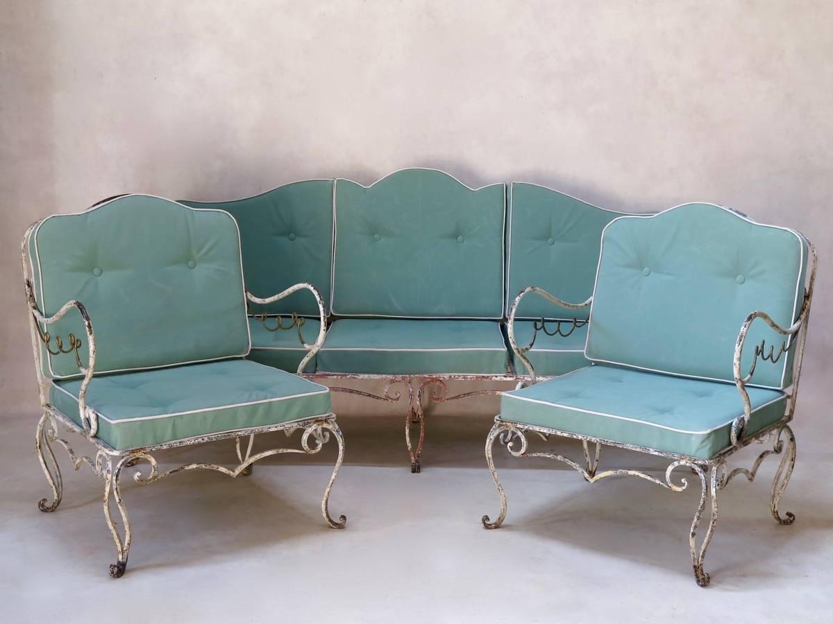 Delightful 1940s Art Deco wrought-iron garden set, comprised of a settee and two lounge chairs. The ironwork is in its original condition, with white and gold paint. The set is heavy, and of lovely quality. Upholstered in delicate, pale green canvas