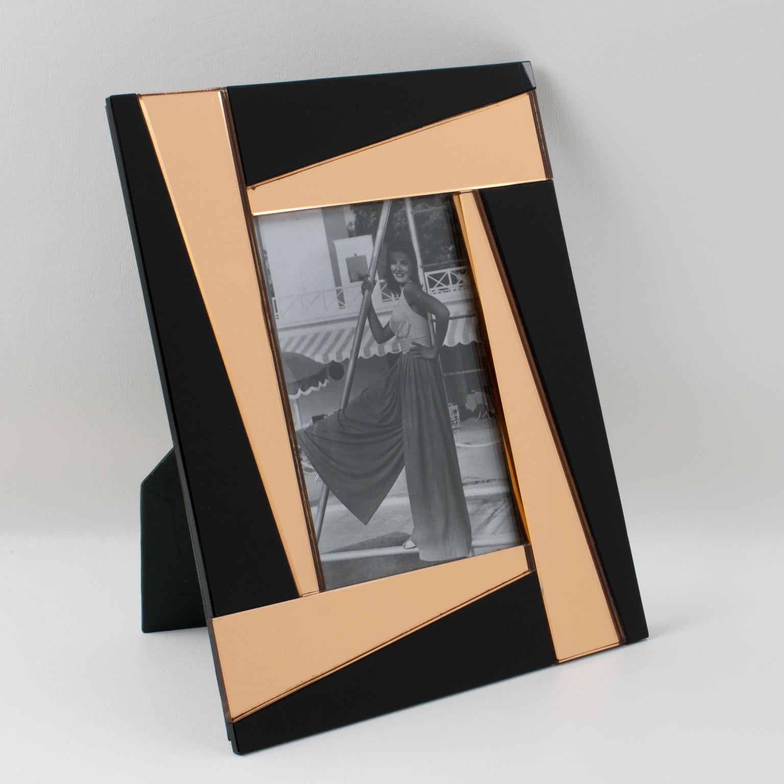 A charming French 1940s mirrored picture photo frame. Beveling with a geometric pattern in lovely copper or pink peach tone contrasted with black colored mirror. The frame can be placed either in portrait or in landscape position. The back and easel