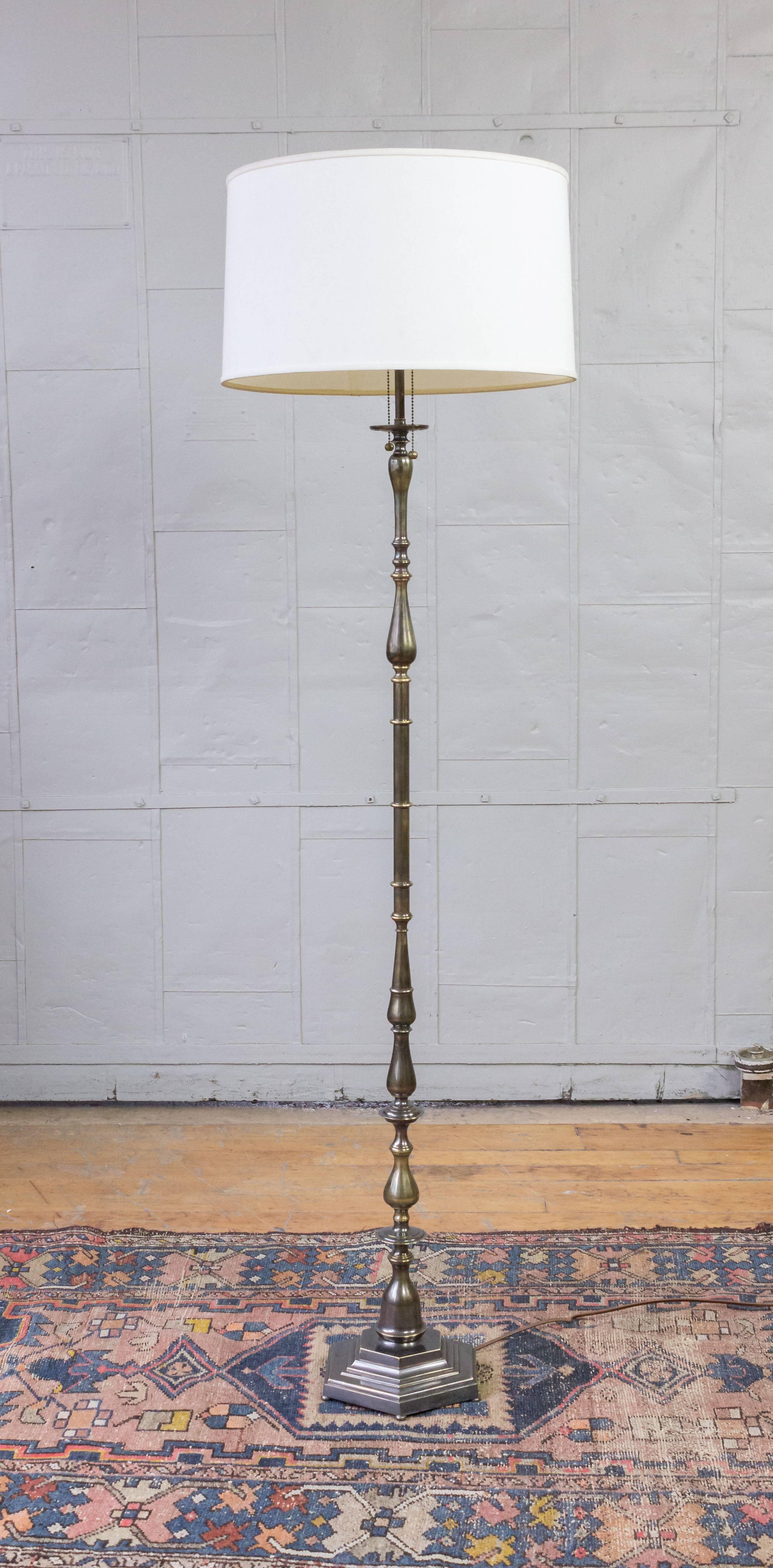 This French 1940s brass and bronze floor lamp is a timeless piece that brings an air of sophistication to any space. The turned and cast bronze parts have recently undergone meticulous refinishing, paying attention to every detail. The lamp features