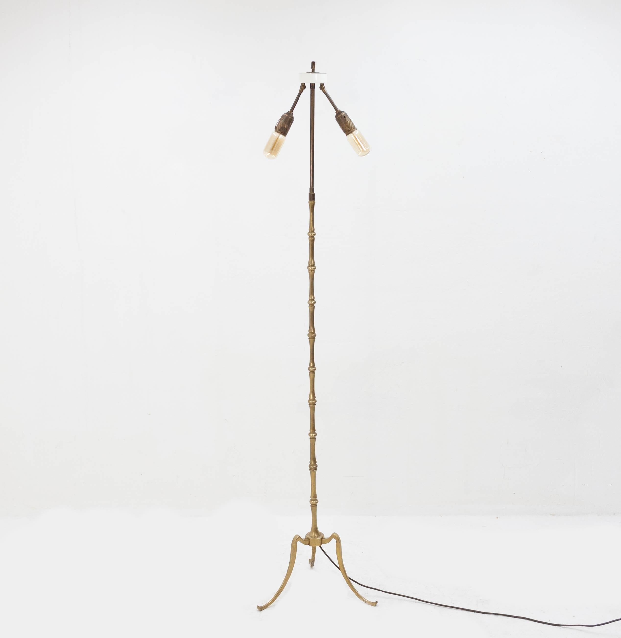 Very elegant and sleek standing tripod brass floor lamp with two adjustable bulbs. This lamp is all original
and in good working order and even still has the original pull cord switches.