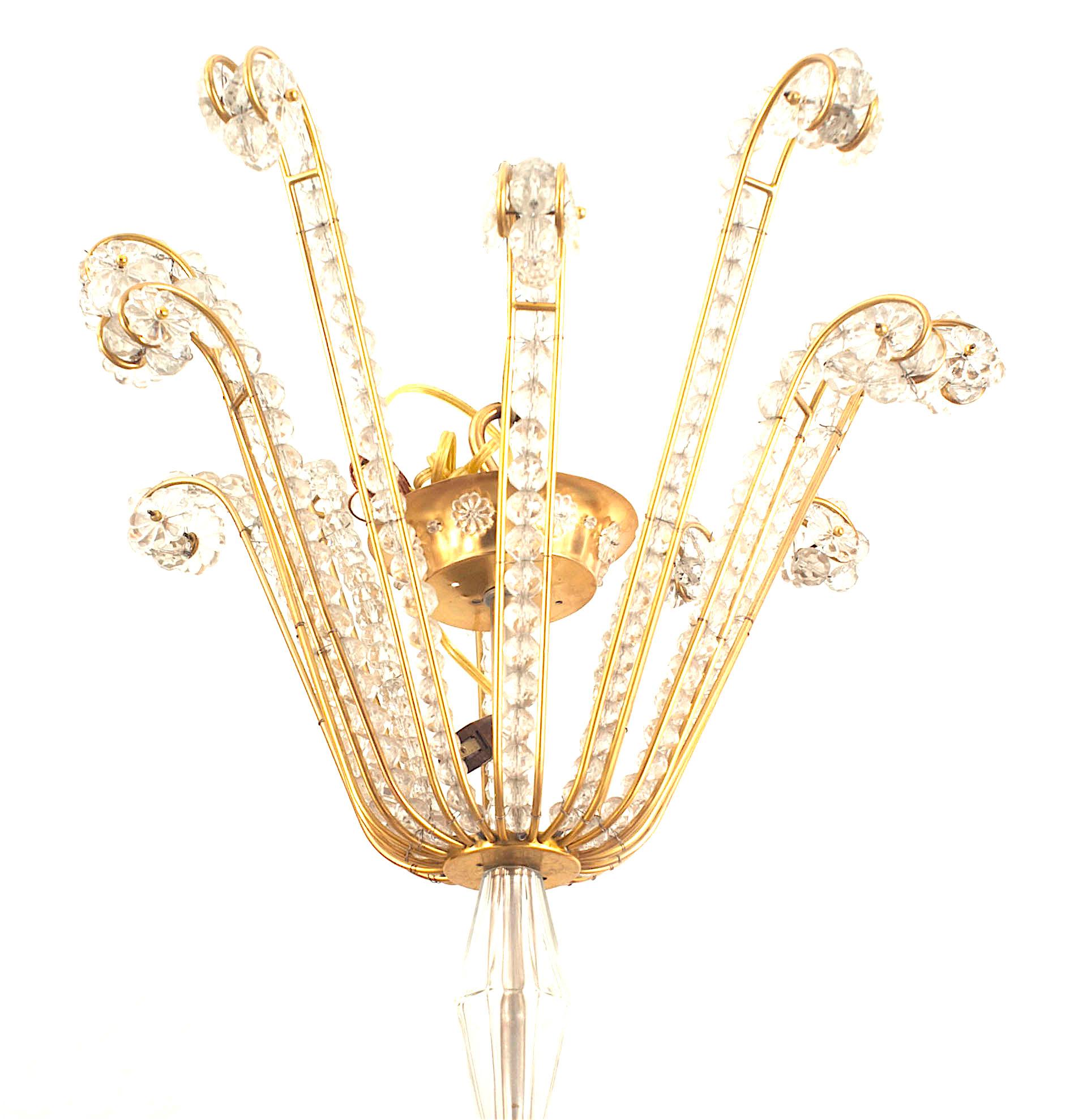French Mid-Century (1940s) brass frame chandelier with 2 tiers of 6 arms having crystal a channel of crystal beads and rosettes on round bobeches with a crystal ball finial bottom. (BAGUES FOR JANSEN)
