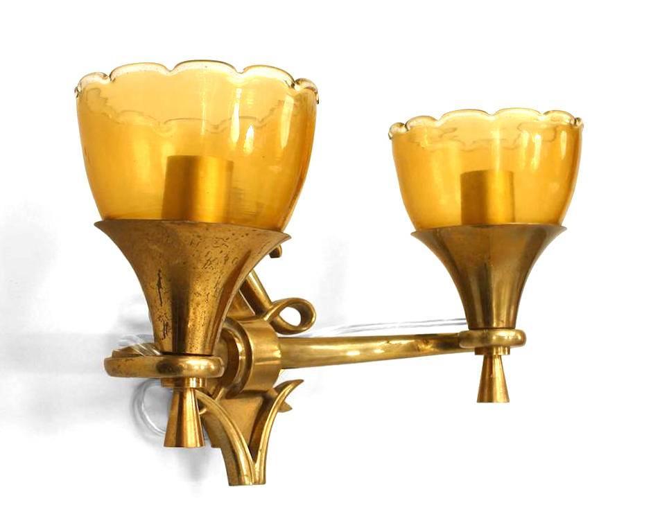 French Mid-Century (1940's) brass 2 arm wall sconces with diamond form & scrolling backplate and amber glass scalloped top shades.
