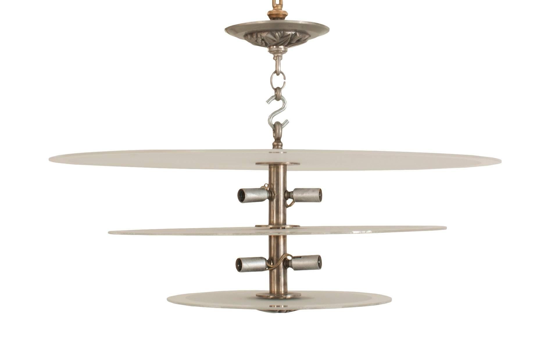 French 1940s chandelier with three graduated round tiered shades of frosted glass with a clear edge supported by a silvered bronze finial having a geometric design.

    