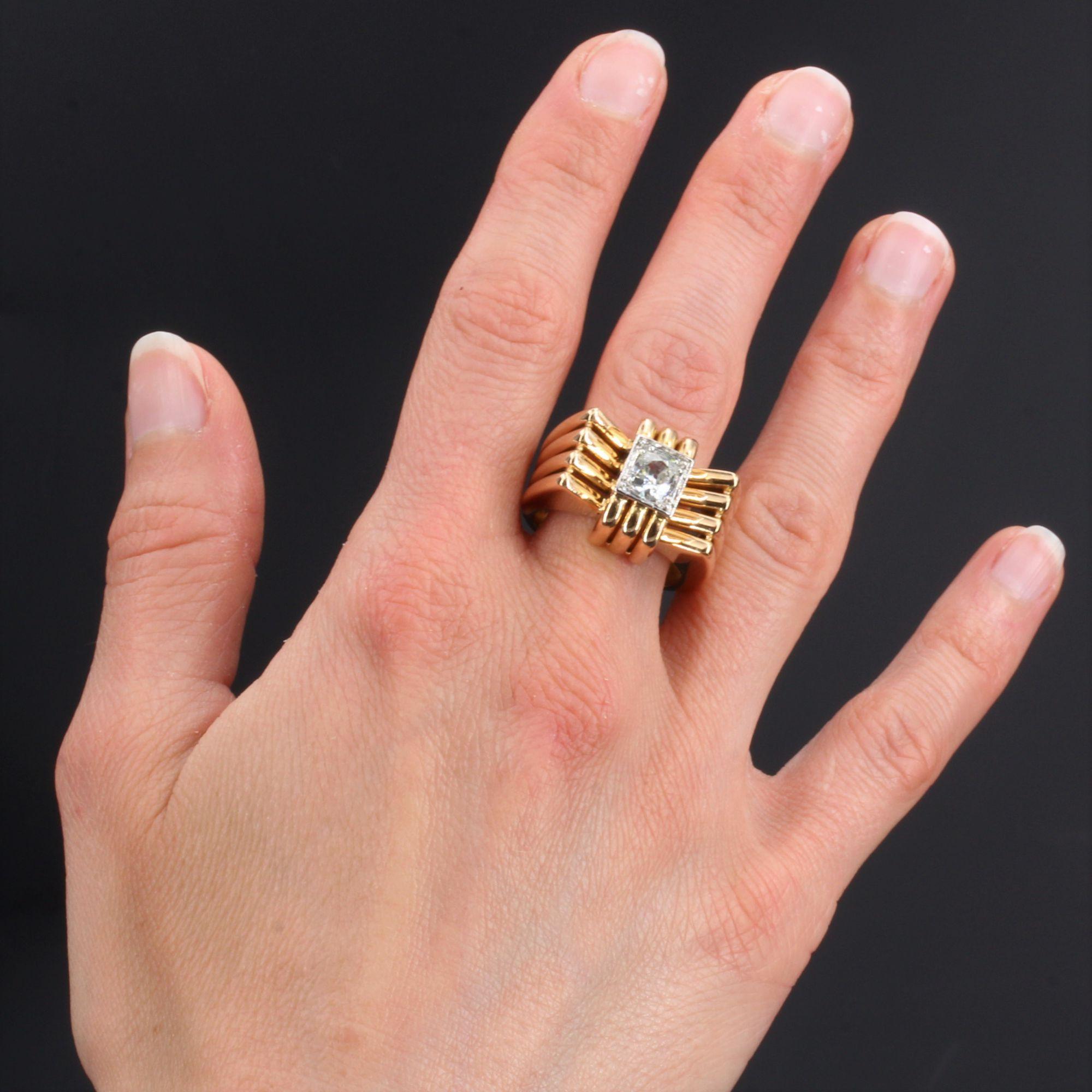 Ring in 18 karat yellow gold, eagle head hallmark and platinum, dog head hallmark.
Important tank ring, it is formed of four flat threads of gold, openwork between them which form the ring and the higher plate in the center of which is set, on