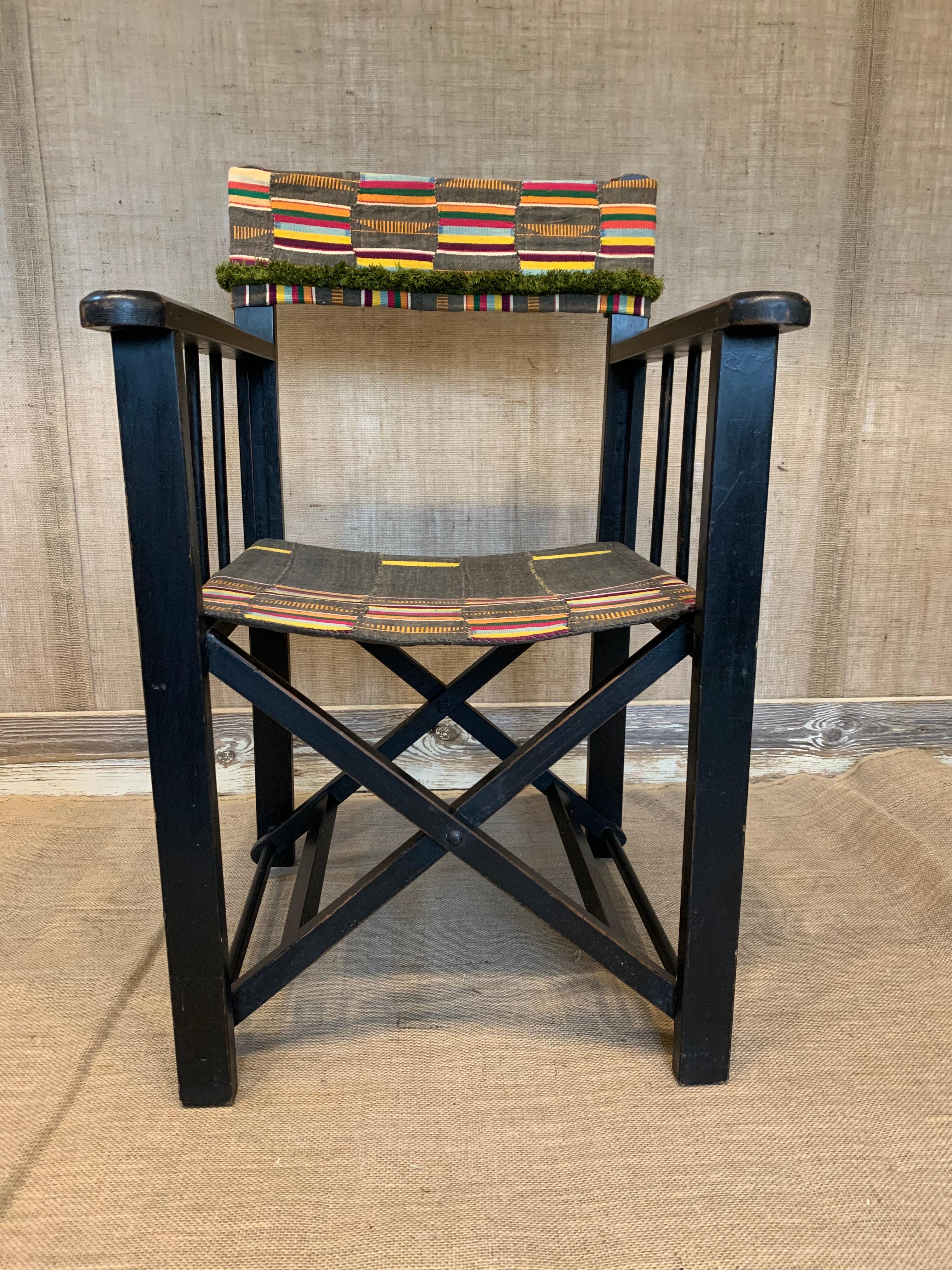 A whimsical folding camp chair in ebonized wood, upholstered with antique African textile. French, circa 1940. Great for your next safari!