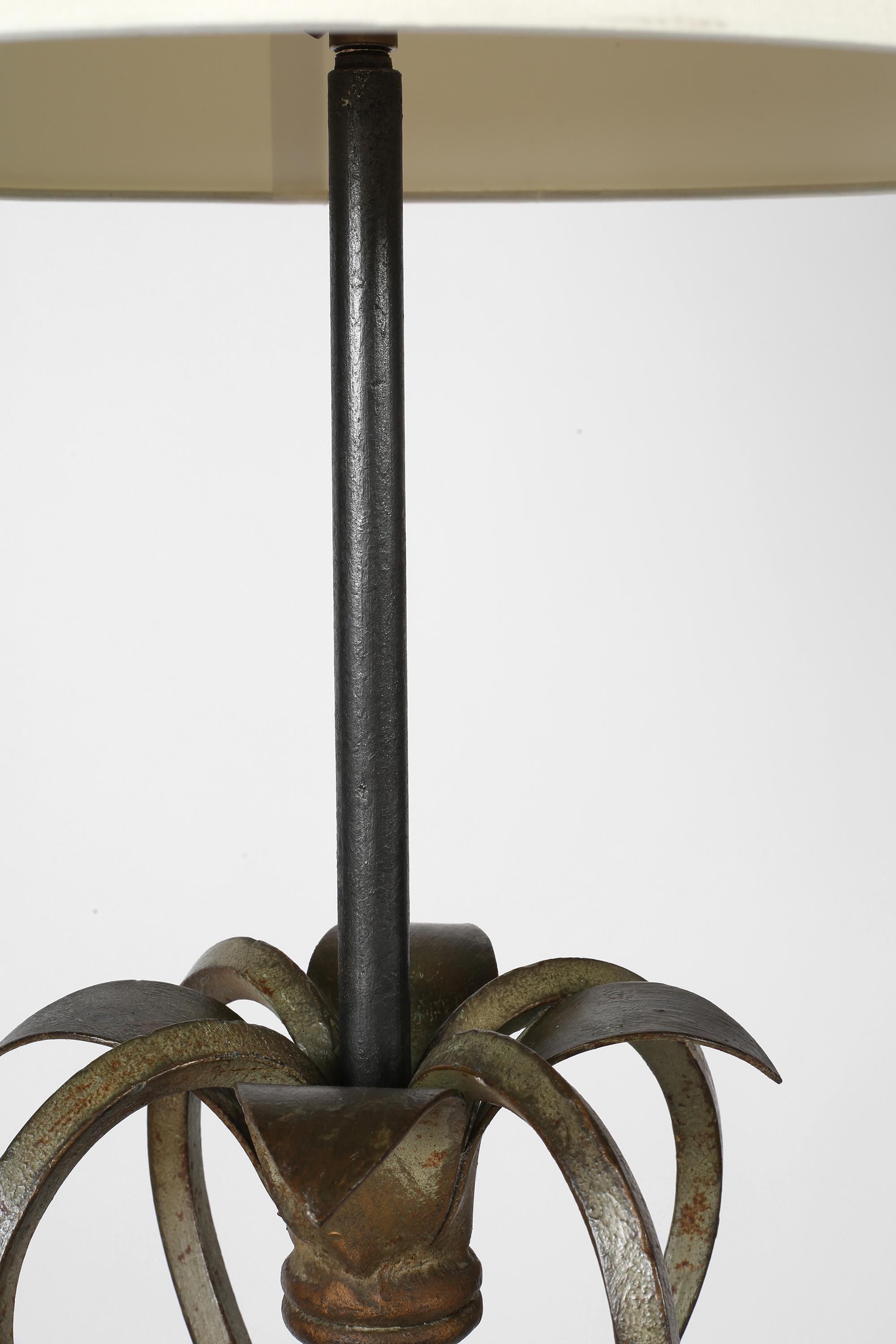 A decorative forged iron floor lamp with painted and gilt, foliate detailing and subtly scrolling, four-point base.

Supplied with a tapered off-white dupion silk shade.