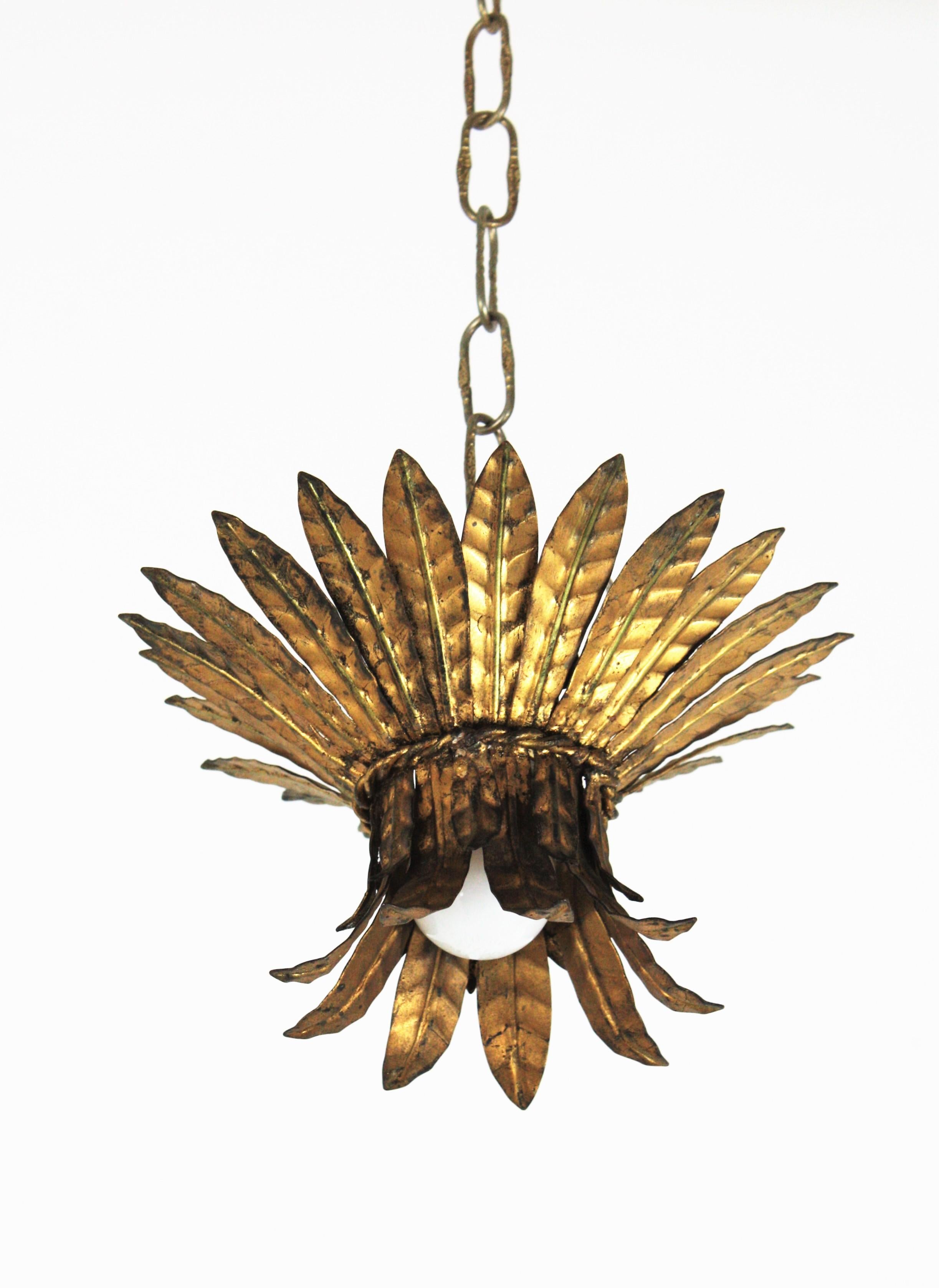 A beautiful Hollywood Regency gilt iron leaves bouquet crown flush mount / pendant. France, 1940s.
This flush mount features a bouquet of iron leaves in two sizes distributed as a crown sunburst and adorned with a twisted iron rope. It has one