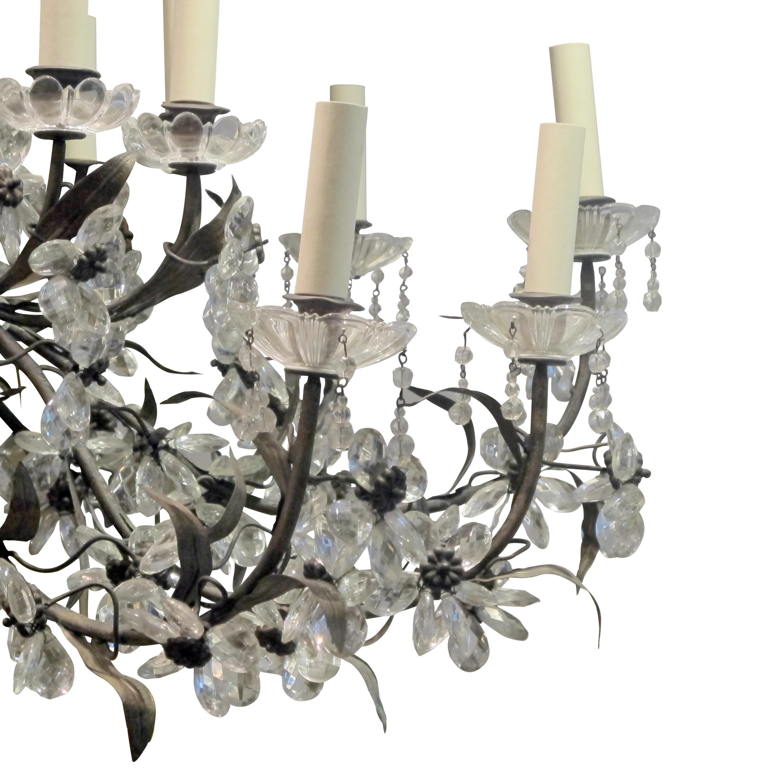 This is a magnificent large leafy chandelier meticulously crafted with a profusion of crystal flowers on a brass and toleware frame. This 1940s French chandelier is a real statement piece with 24 branches. The chandelier has been rewired to the UK