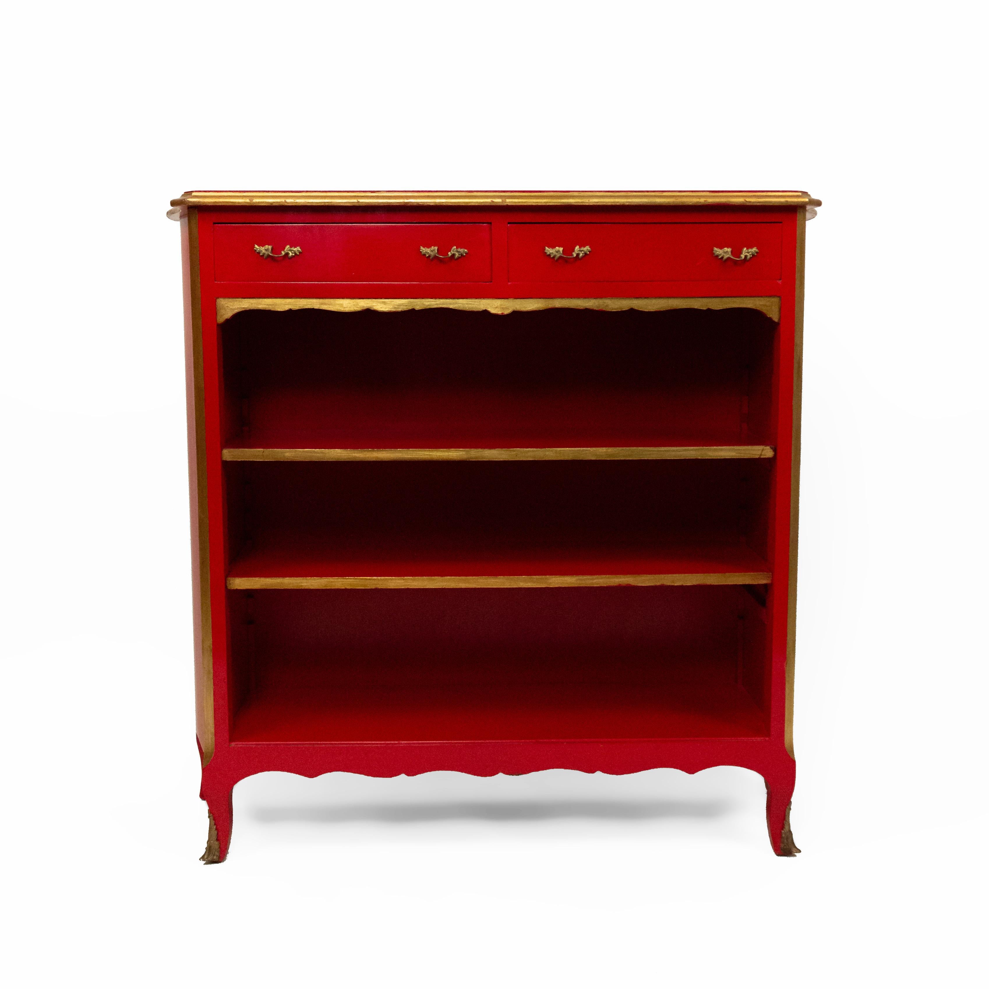 French Louis XV-style (1940s) red lacquered and gilt trimmed bookcase with 2 drawers above 3 shelves with a shaped top and bronze sabot feet. (Stamped: JANSEN)
