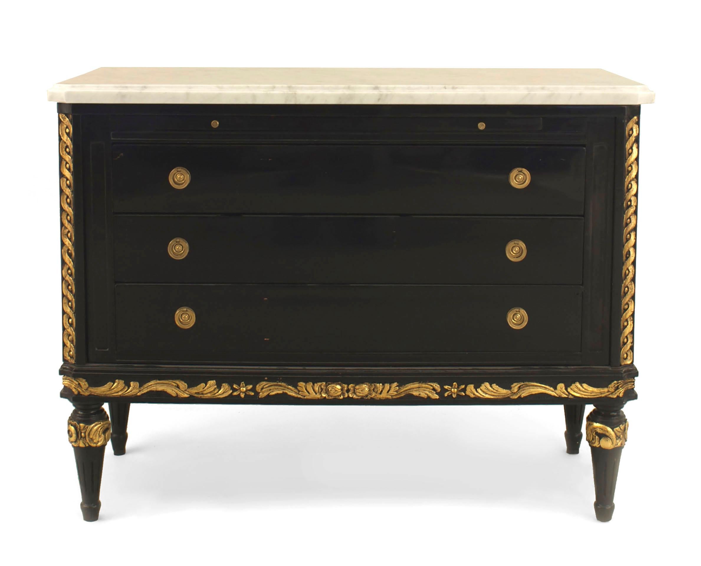 French Louis XVI style (1940s) ebonized chest with gilt carved sides and legs and 3 drawers having ring handles under a front slide shelf and a white marble top (signed: JANSEN)
