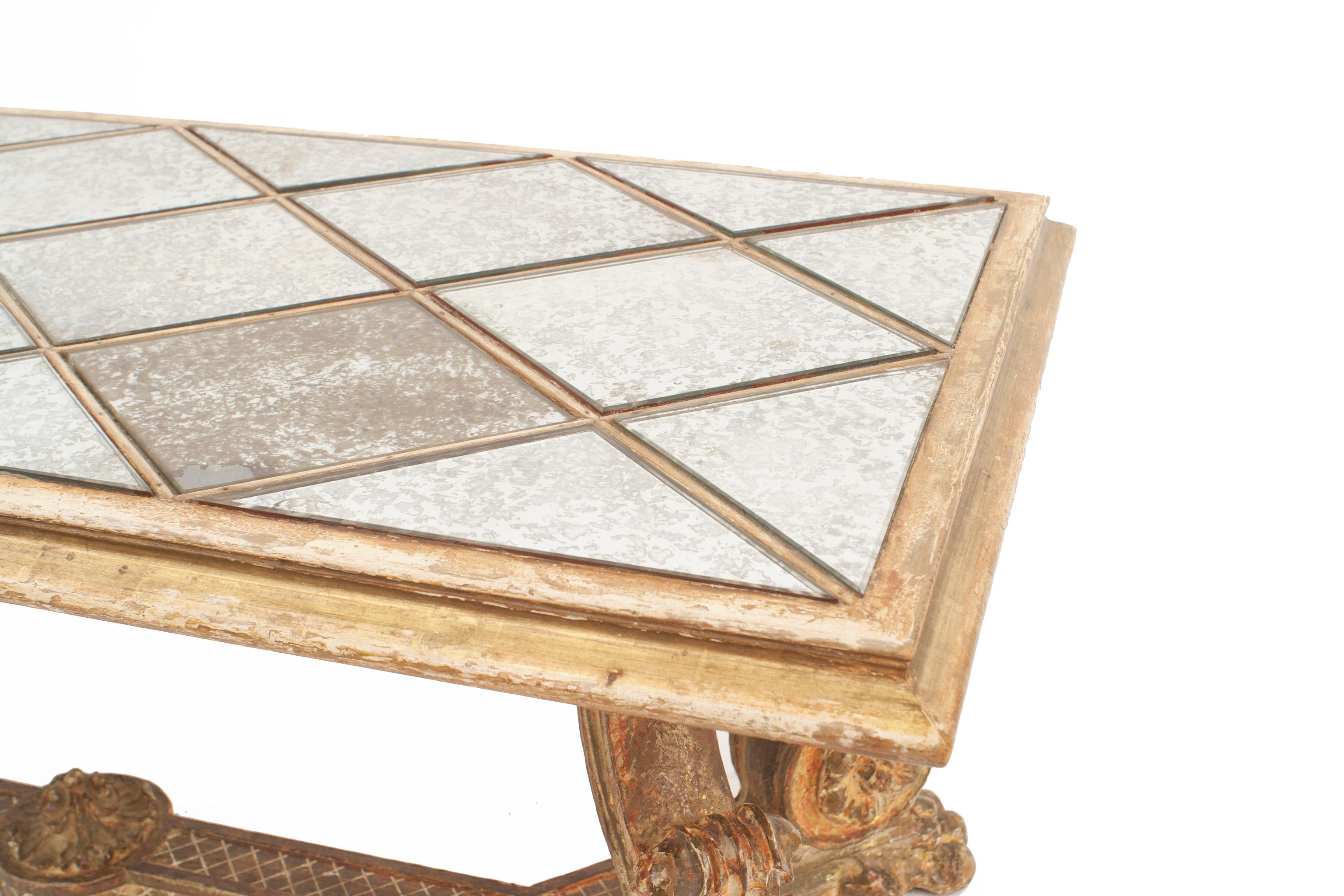 Table basse rectangulaire en chêne doré, datant du milieu du siècle dernier (années 1940), avec des pieds sculptés en forme de volutes reliés par une traverse et un plateau en losange en miroir vieilli.
