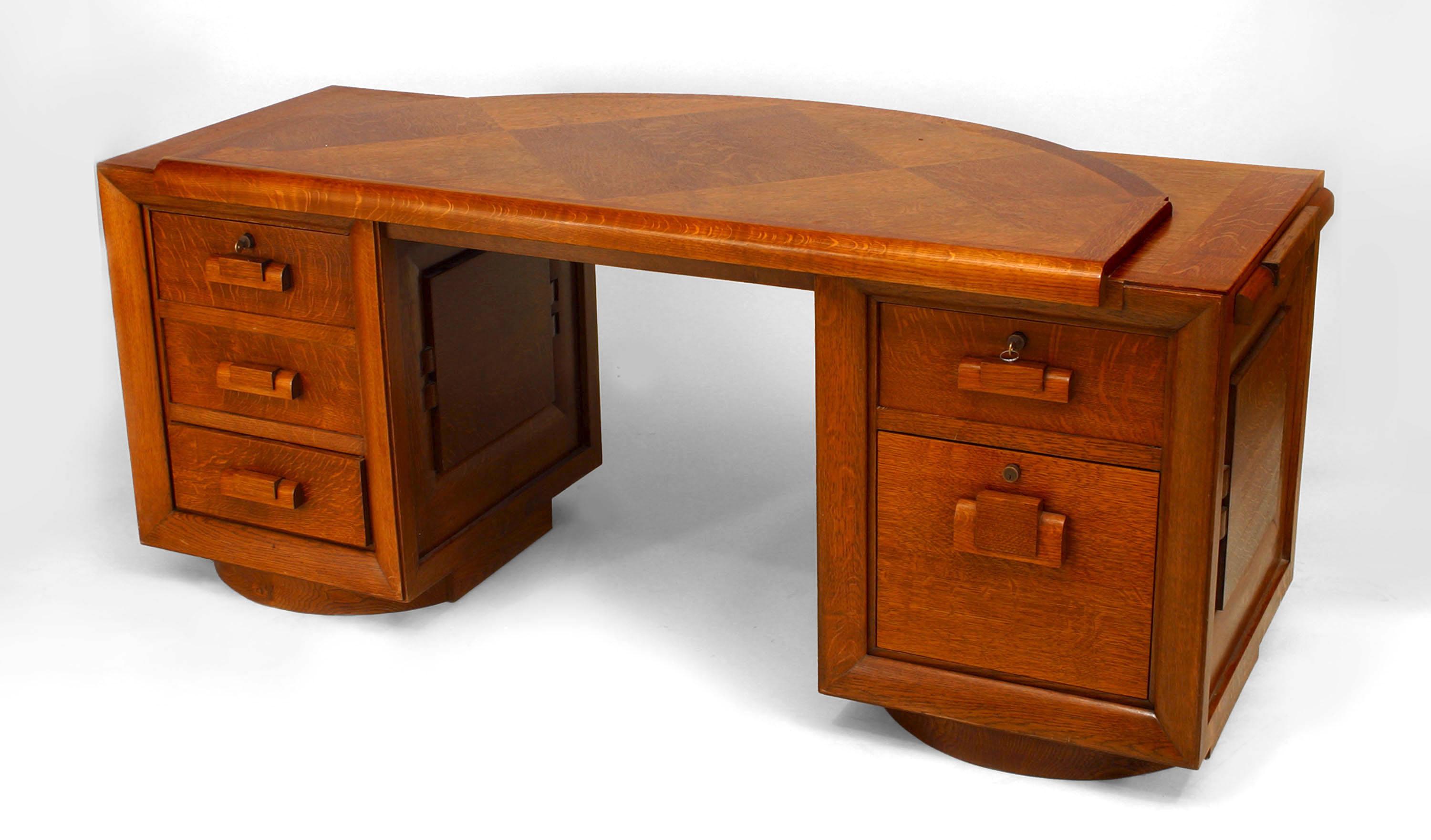 French 1940s oak double pedestal base desk with front panels and a raised ¬Ω round inset top with a parquetry design & sliding side shelves (signed: C. DUDOUYT) (Related Item: 060336A).
