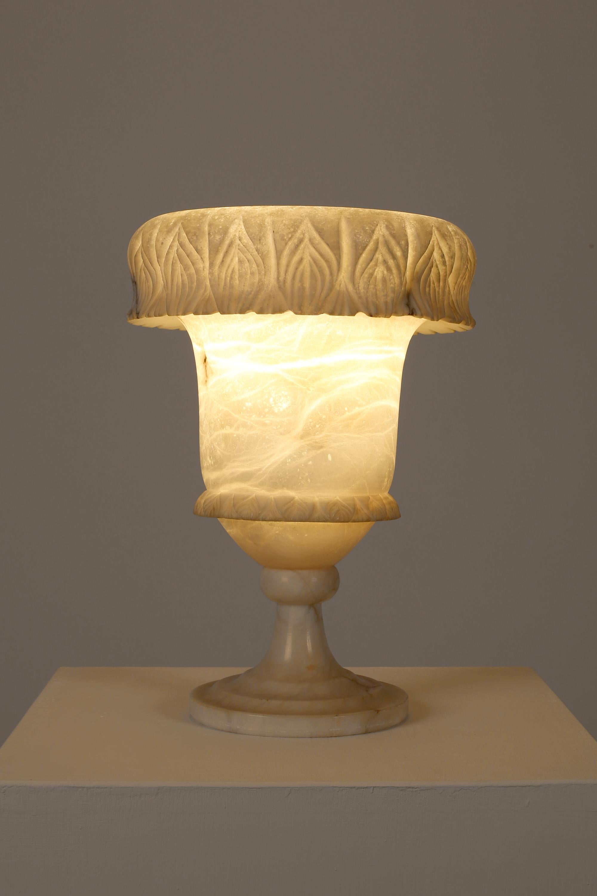 Lampe de table en marbre d'albâtre blanc cassé, tournée et sculptée, de forme ornementale en forme d'urne avec des détails feuillagés. Français, c. 1940s.