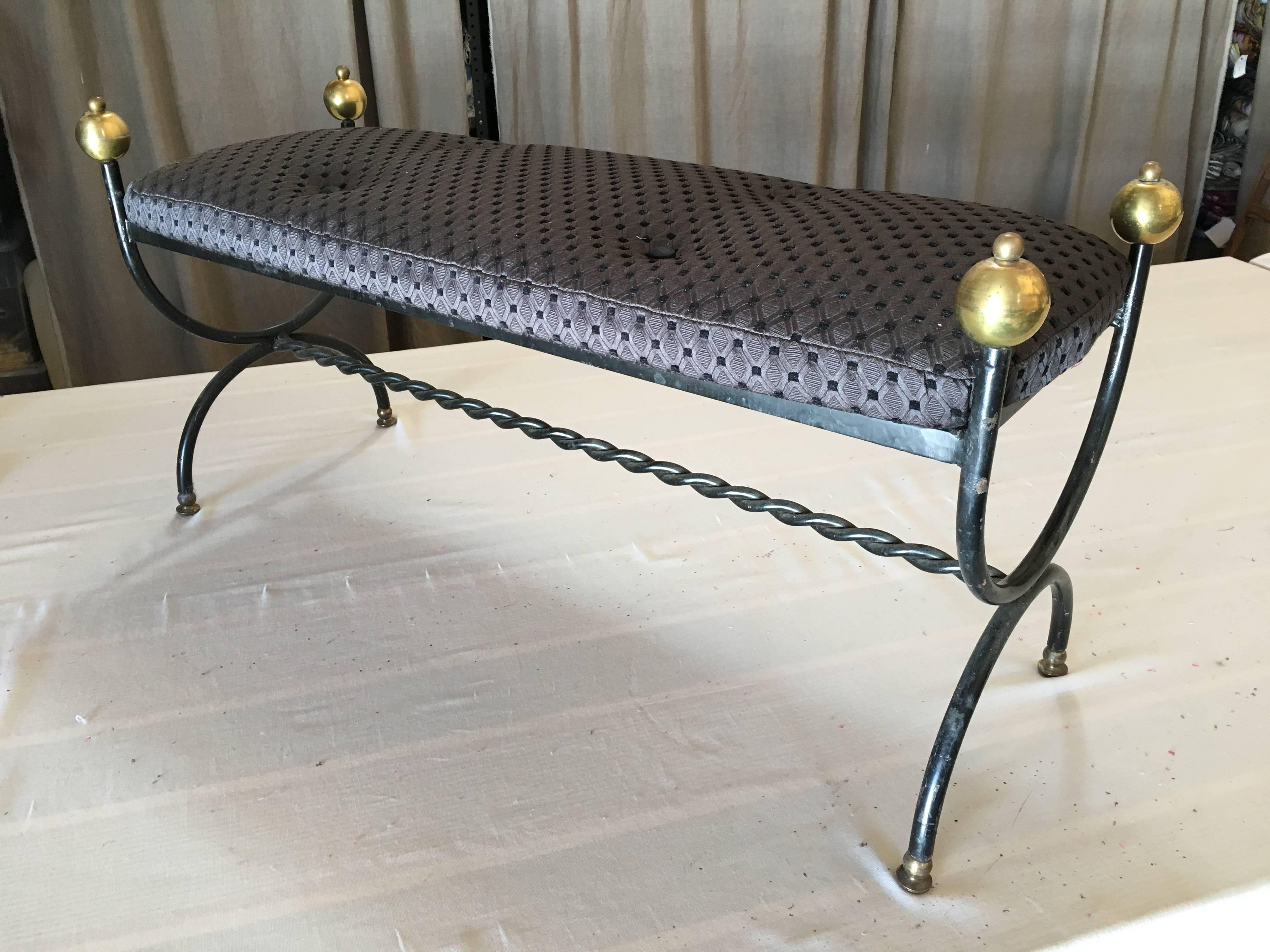 A French 1940s bench in tubular steel with brass details, in the manner of Jean Royere, recently upholstered in dark grey linen with button tufting.