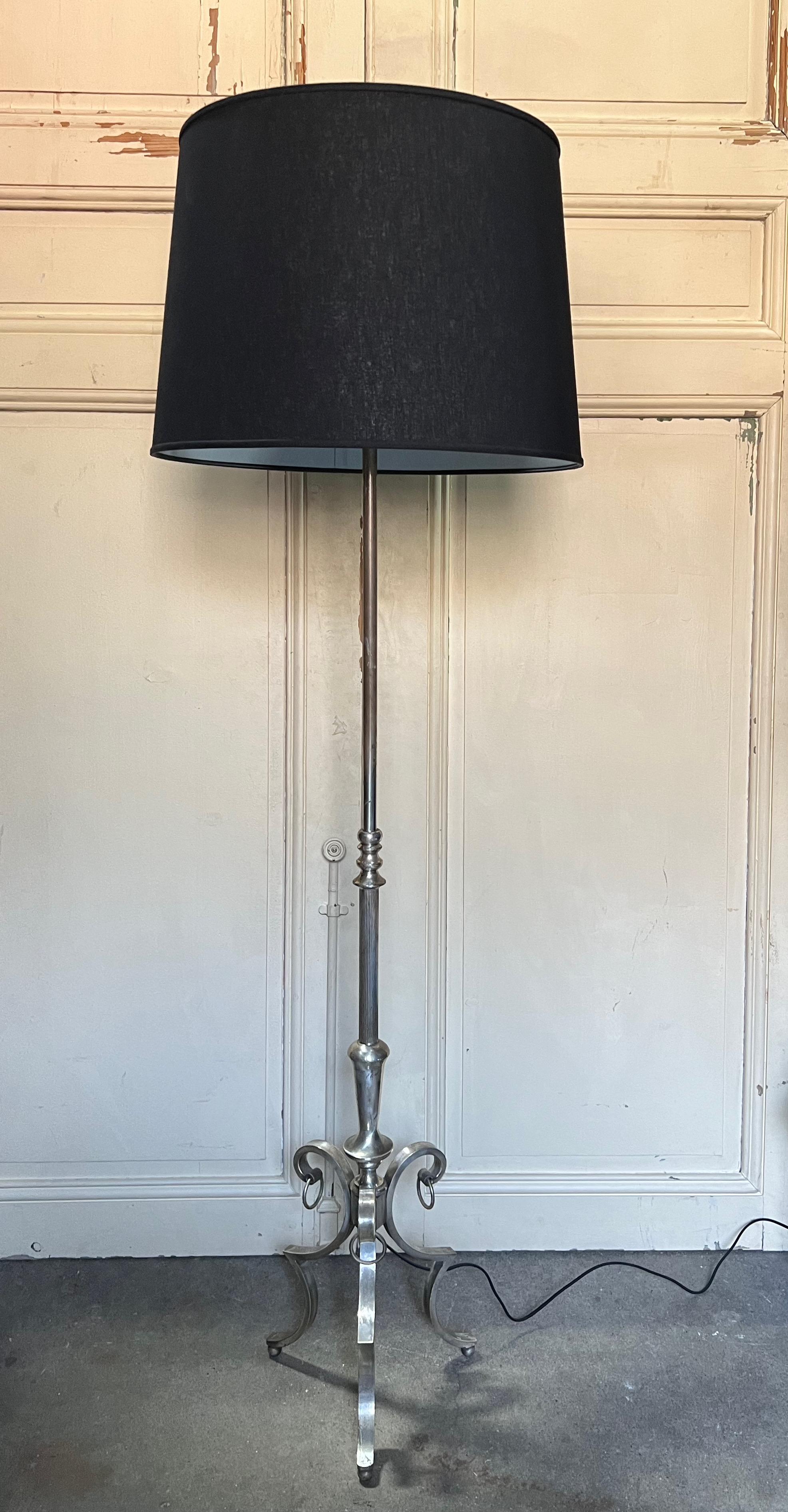 Introducing a sophisticated French 1940s floor lamp with a hand-polished patina that accentuates its vintage allure. The tripod base gracefully rests on ball feet, elegantly complemented by rings that beautifully contour the legs. The stem showcases