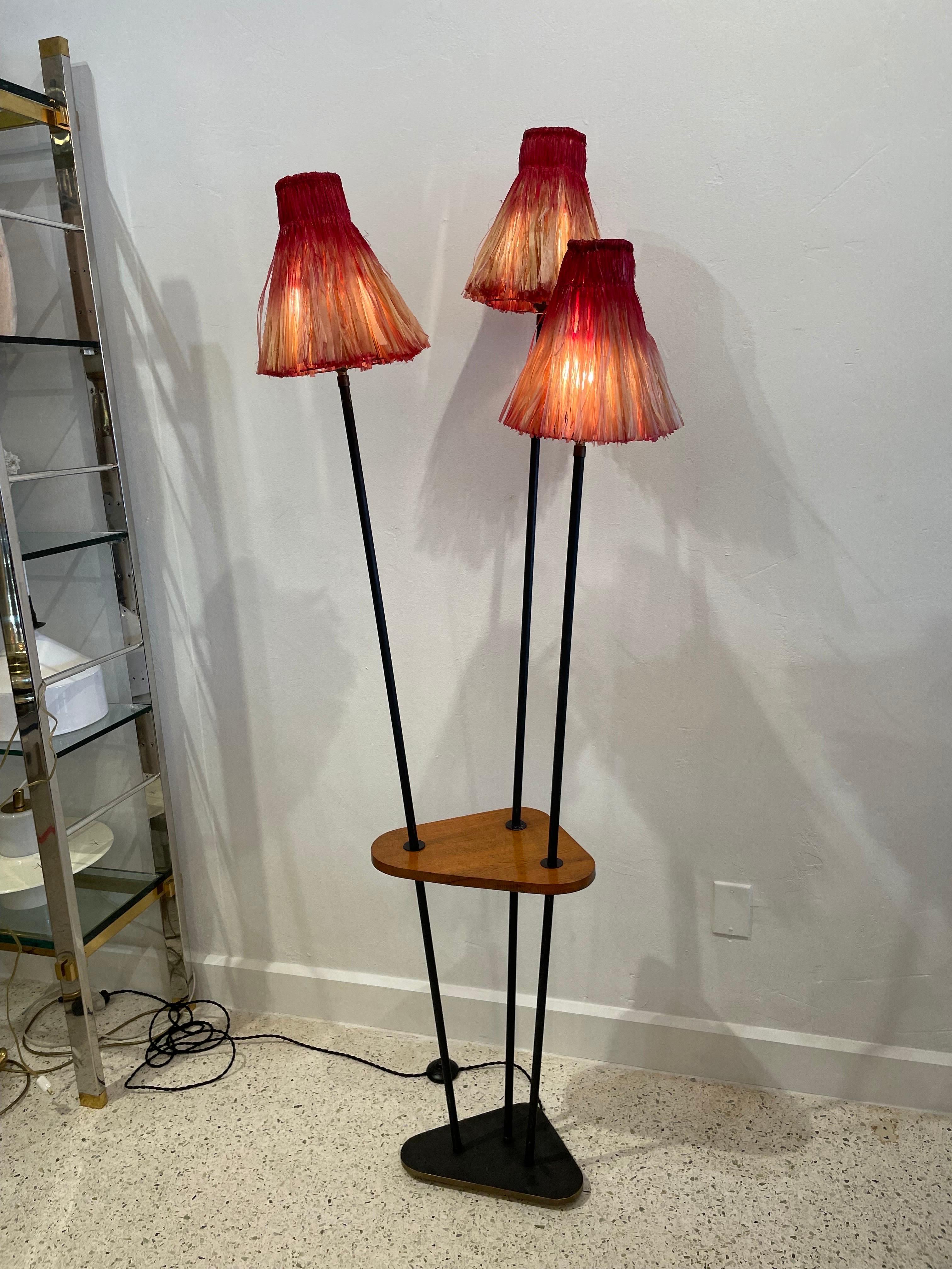 This French 1950's 3-arm floor lamp with floating wood drinks plateau is accented wonderfully by its natural raffia Tiki shades. This calls to the French Polynesian aesthetic, very mid-century and at the same time, modern and chic! This would fit in