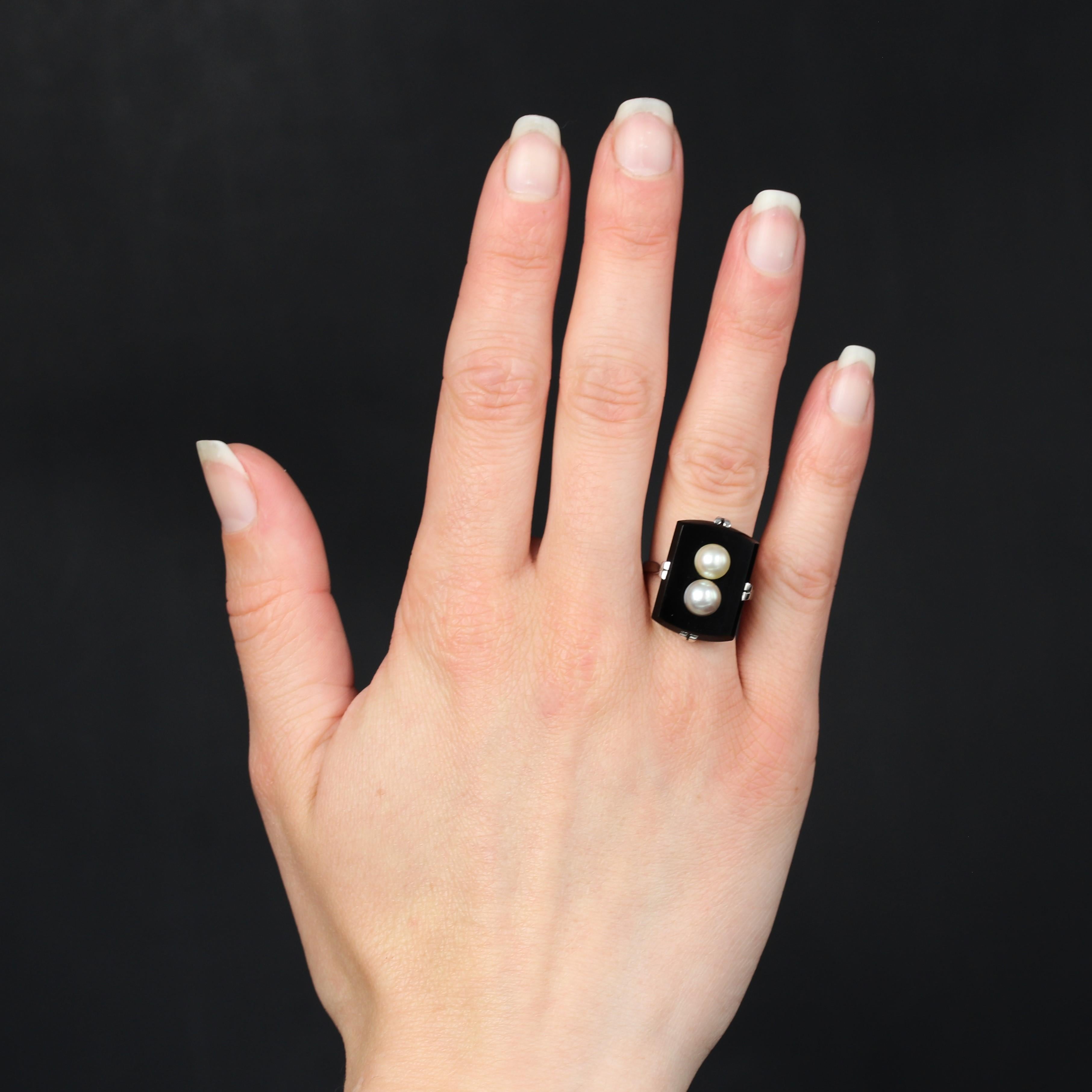 Ring in 18 karat white gold, eagle head hallmark.
In the Art Deco ring style, the white gold setting of this antique ring is openwork and formed of 4x2 flat claws that hold a rectangular onyx slightly rounded on 2 sides. The onyx is pierced in the