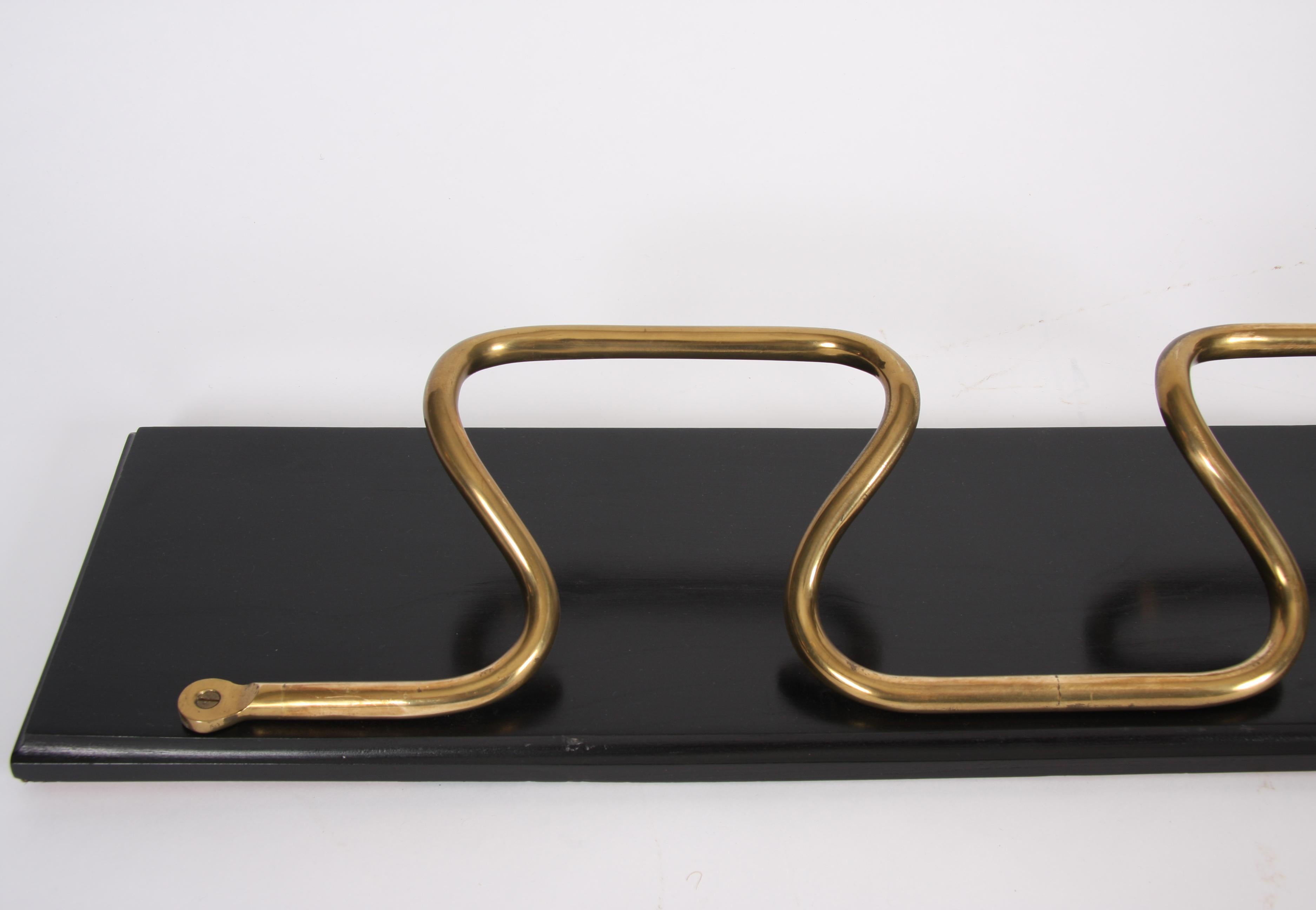 This beautiful brass and ebonized wood clothes rack dates back to 1950s France.