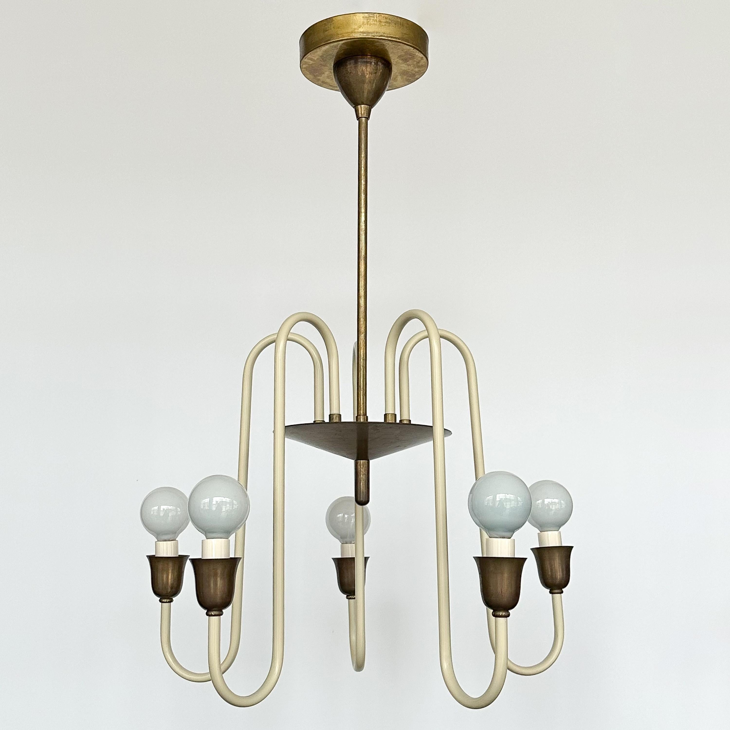 A cream lacquered and brass five light chandelier, France circa 1950s. This chandelier features 5 curved cream lacquered stems that radiate from a central brass hug and terminate with tulip shaped cups. The hardware is a beautifully patinated brass.