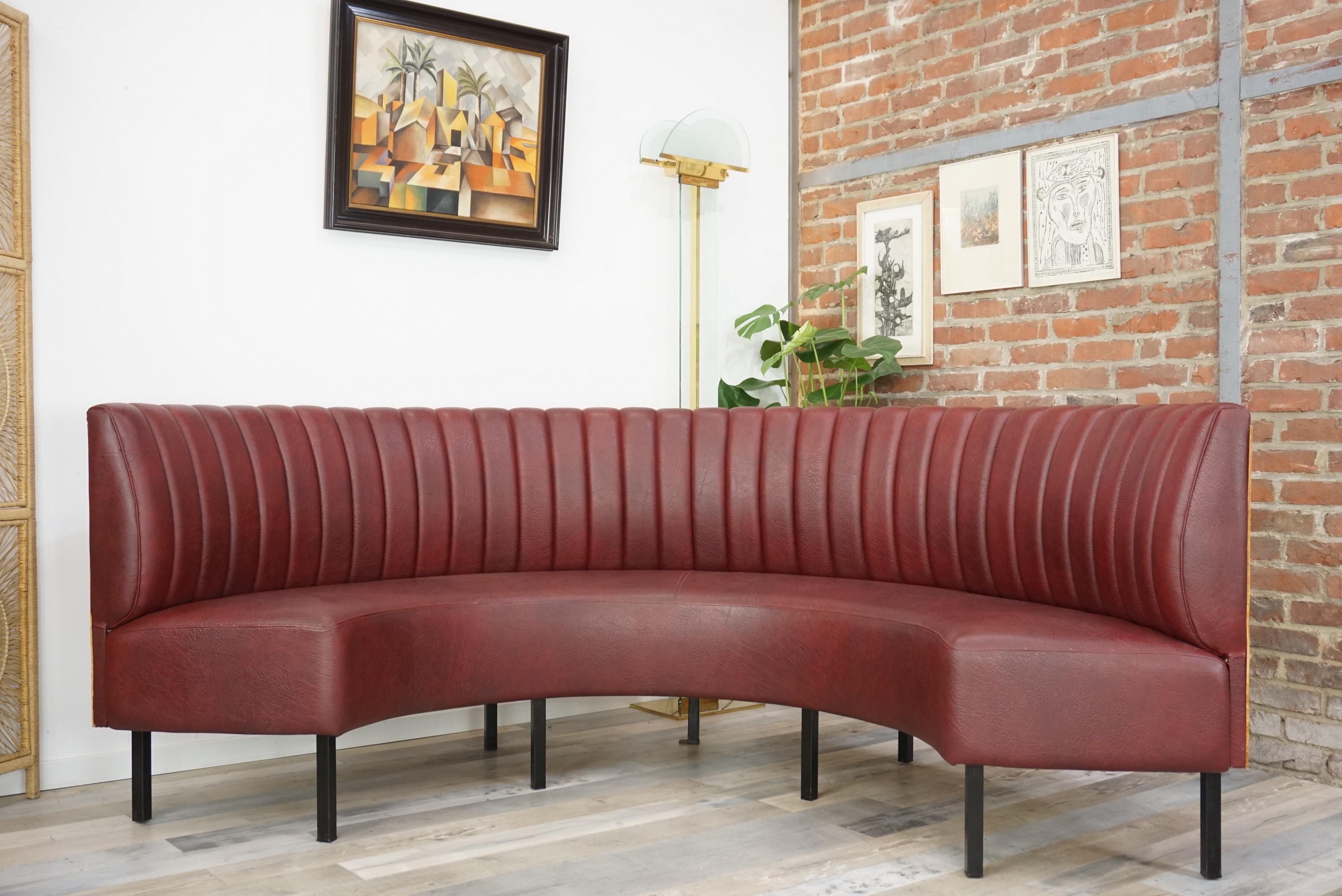 Straight way from the 1950s, this sofa come from an old French bistro. Composed of a half-moon shell worn with Bordeaux color faux leather, square black metal feet and a curved wood back. Amazing, outstanding and gorgeous!