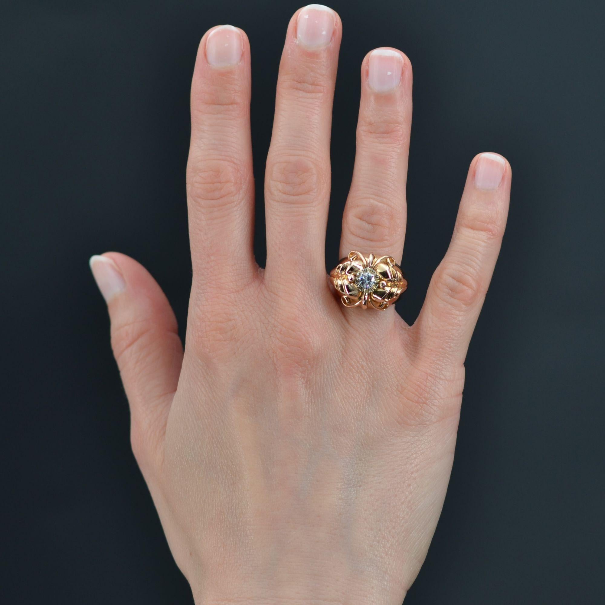 Ring in 18 karat rose gold, eagle head hallmark.
Large and domed, this antique ring is adorned on top with a modern brilliant-cut diamond held in a claw. The dome of this retro ring is decorated with arabesques, gold pearls and plant motifs on the