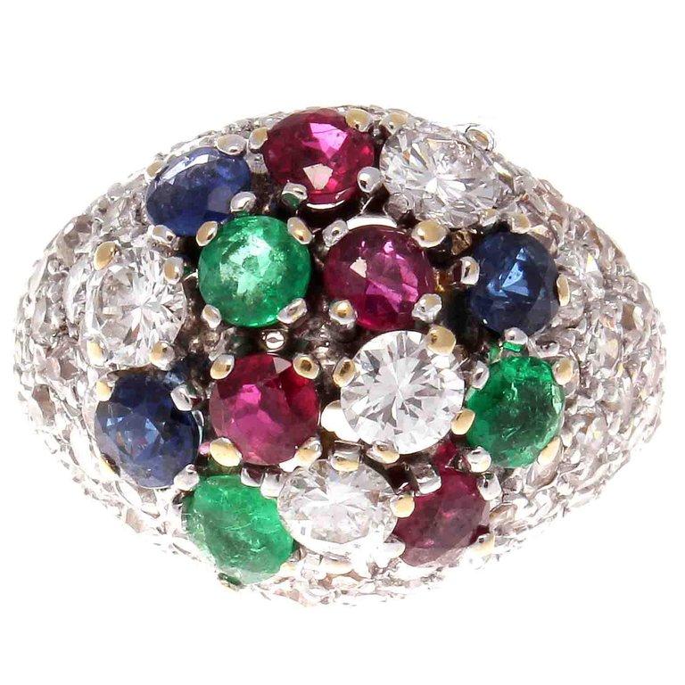 This colorful ring is in the best tradition of tutti fruti, playful, light hearted and charming. Featuring numerous new colorless diamonds mixed with vivid blue sapphires, red rubies and green emeralds. Hand crafted in 18k gold. Stamped with French