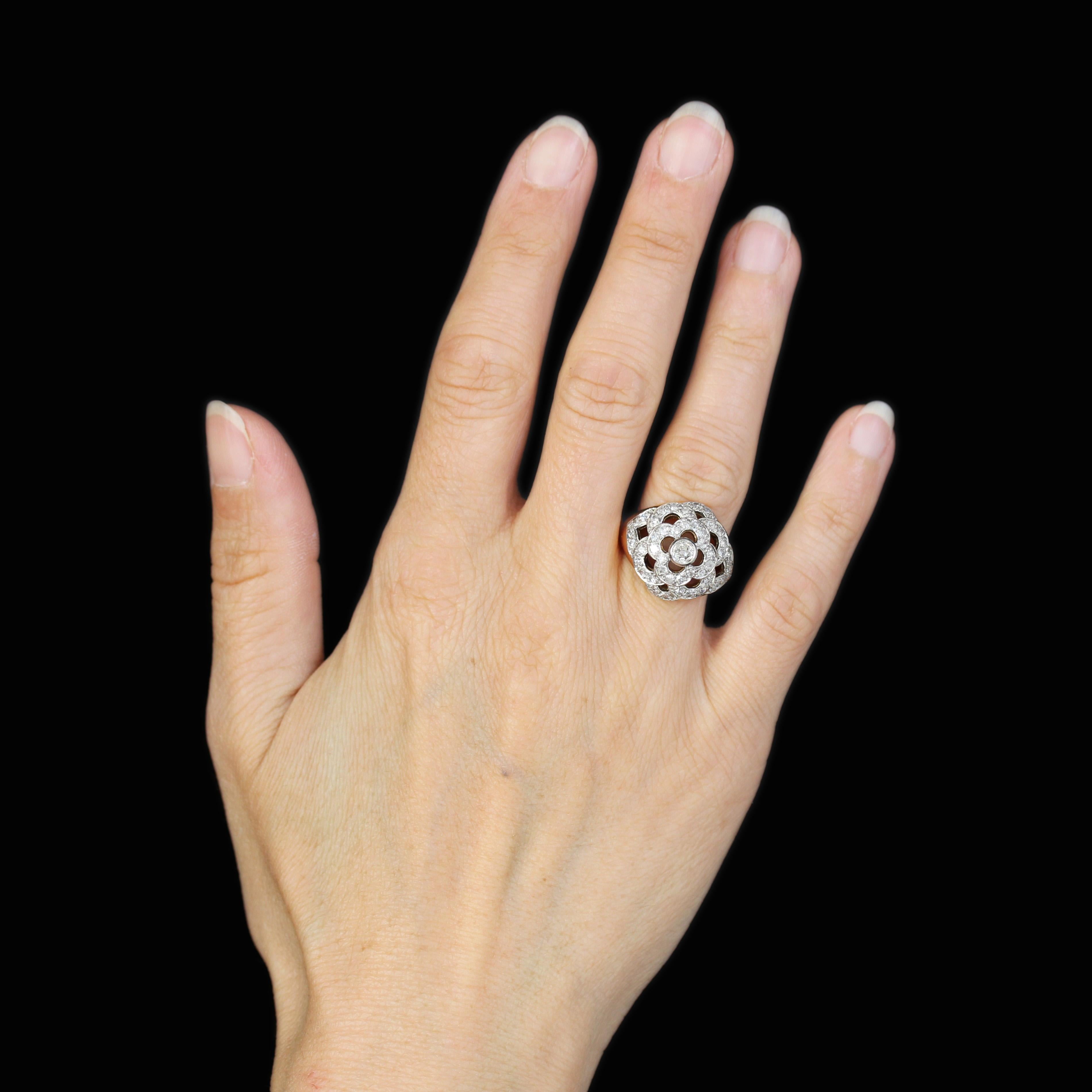 Bague en or jaune 18 carats, poinçon tête d'aigle et en platine, poinçon tête de chien.
Ravissante bague dôme, elle est ajourée sur son sommet et sertie de diamants sur un motif floral. Celui du centre est plus important.
Poids du diamant principal