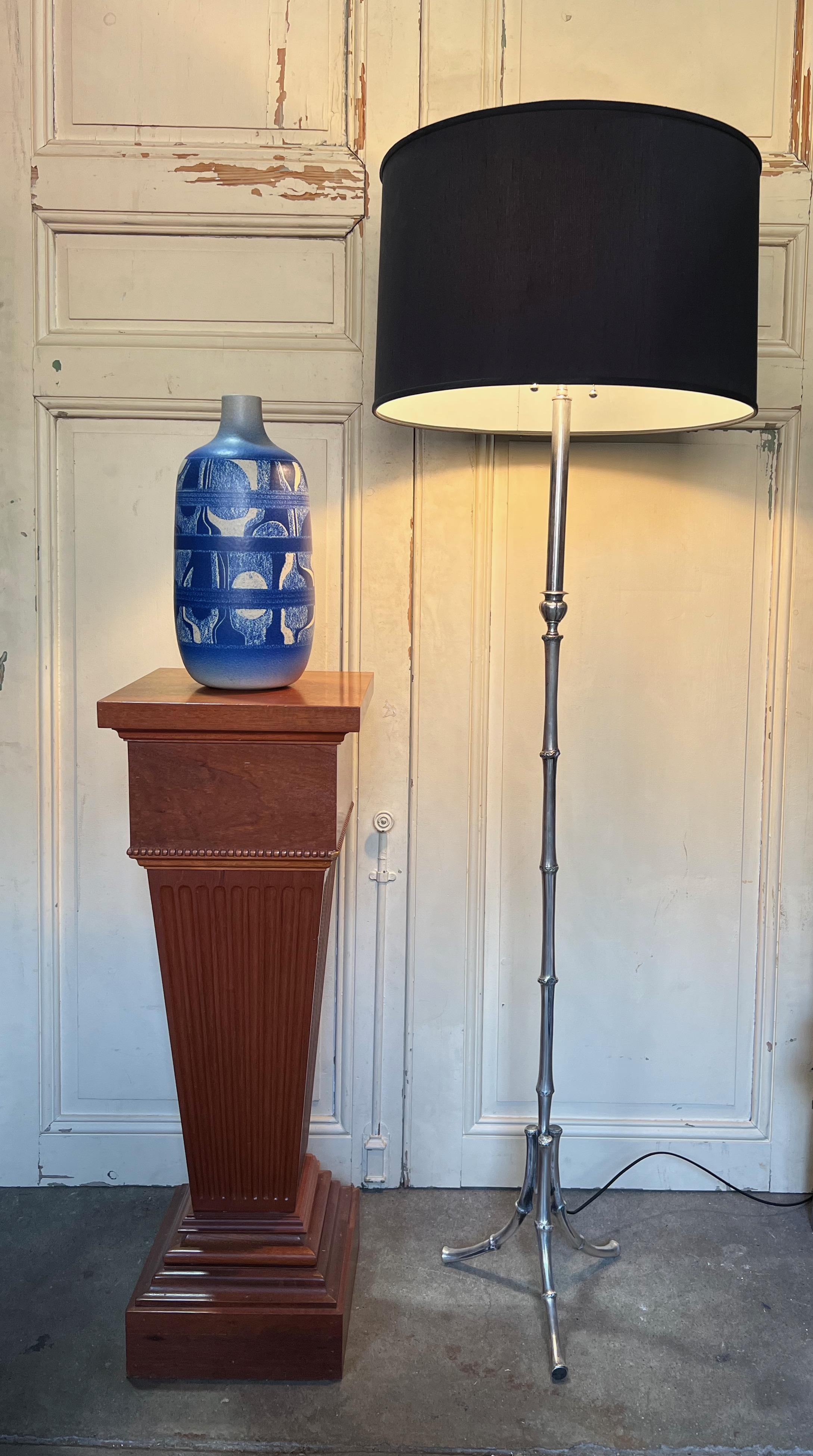 Introducing a stunning French 1950s floor lamp in the Chinese Modern style with a faux bamboo motif. This cast brass floor lamp has been hand polished to reveal a soft silver sheen, highlighting its vintage qualities. The tripod base provides sturdy