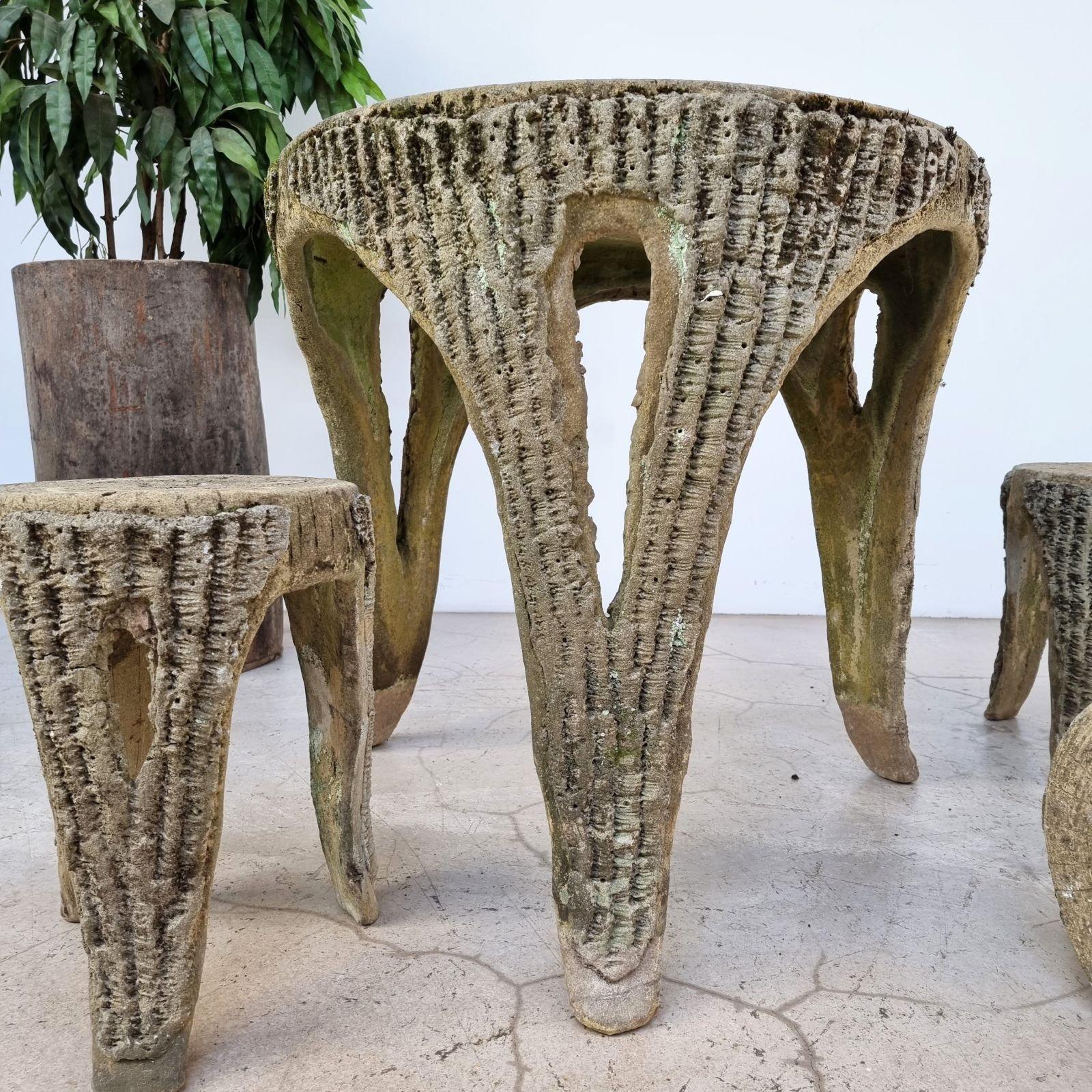 An exceptional French 1950s faux bois cement garden table with stools. The cement material ensures that the set is sturdy and durable, perfect for outdoor use. The faux bois tree bark graining effect adds a touch of natural elegance to the set,