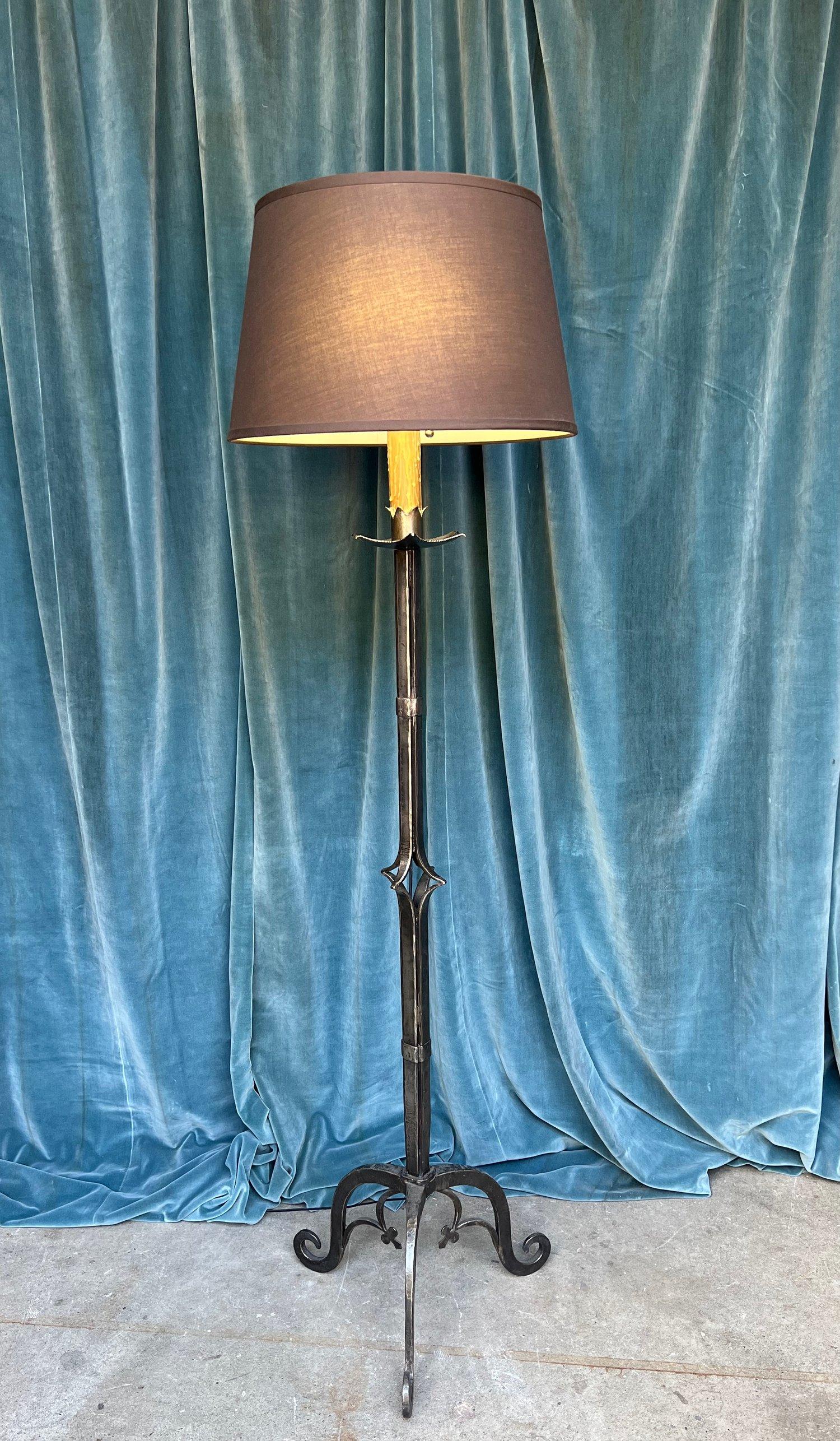 Introducing a very unique French iron floor lamp from the 1940s. This statement piece is a perfect addition to any living room, library, or sunroom. Made from solid wrought iron, the lamp boasts a hand-polished surface that reveals a rich, darkened